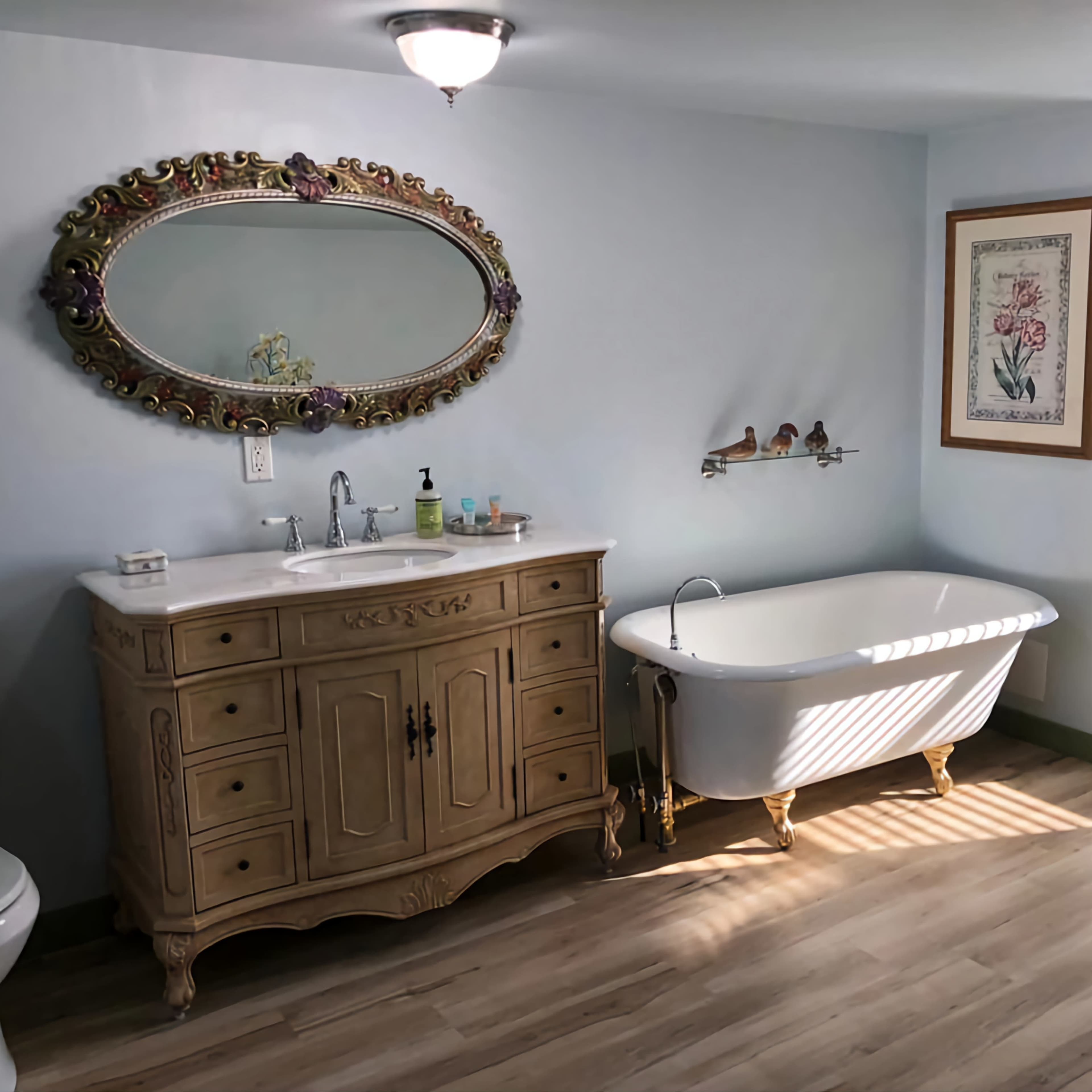A bathroom featuring a vintage wooden vanity with a sink, a freestanding bathtub, a shower area, and natural light streaming through a window.
