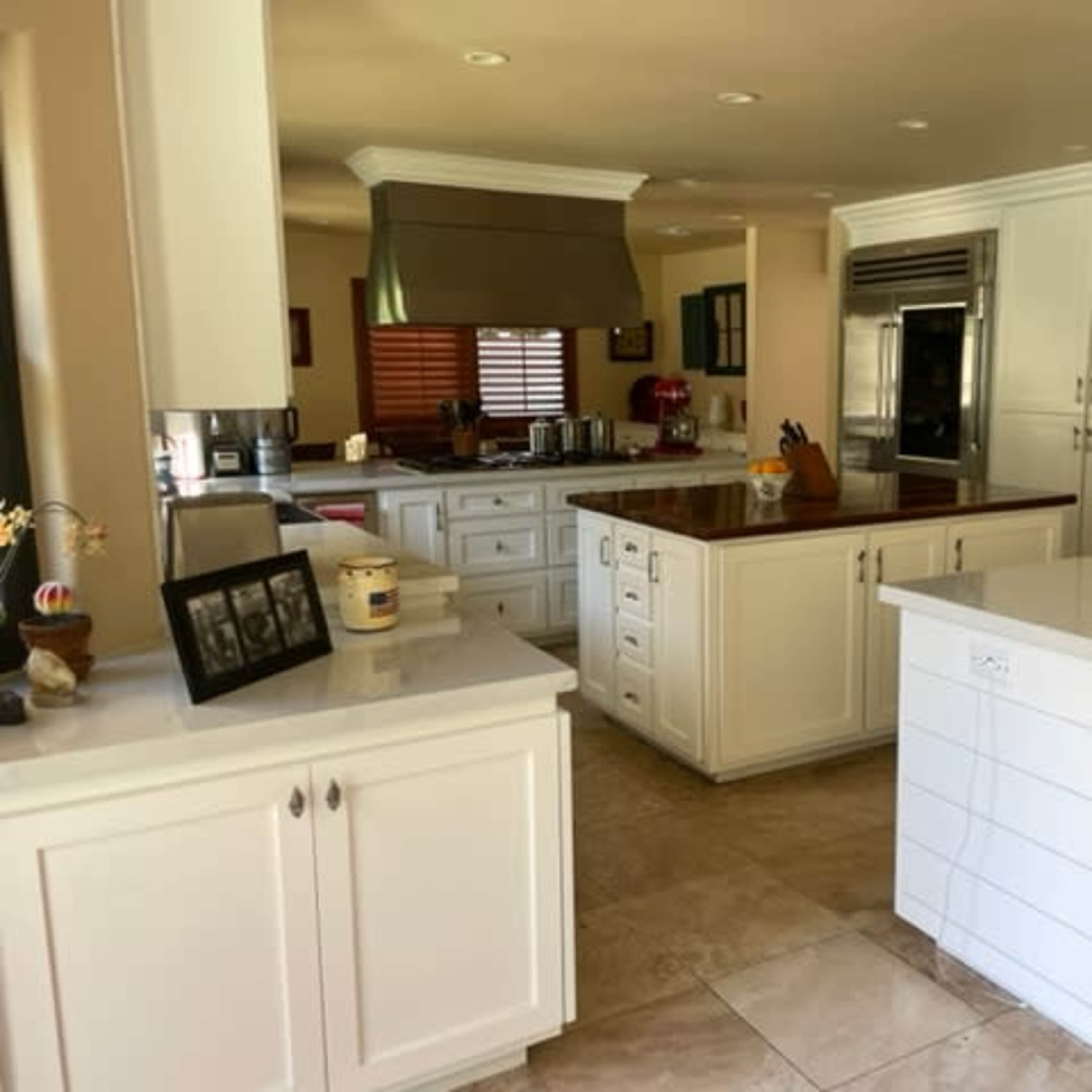 A modern kitchen with white cabinetry, a central island, and stainless steel appliances.
