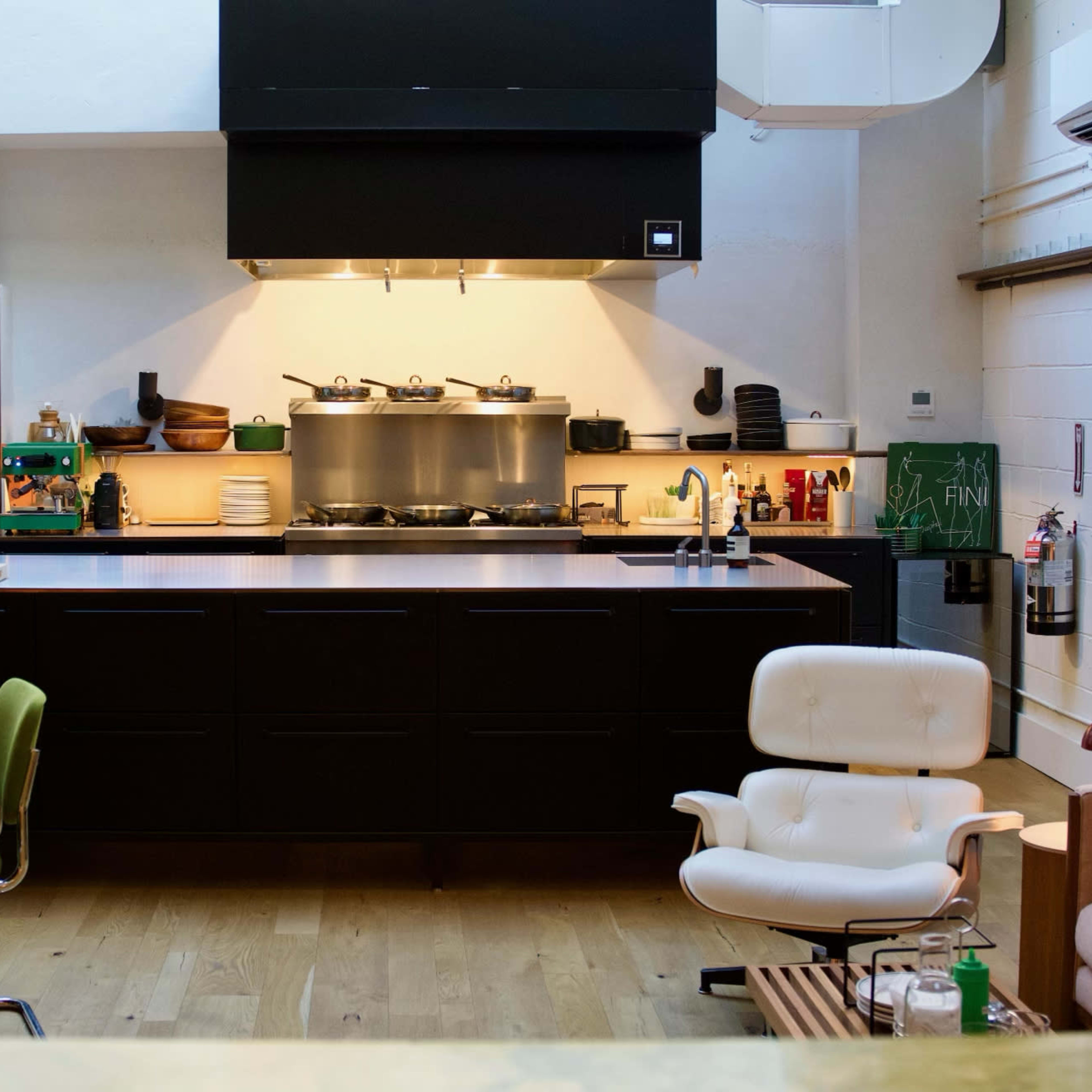 A modern kitchen and dining area featuring a dark cabinetry design, a large island, and a round dining table.