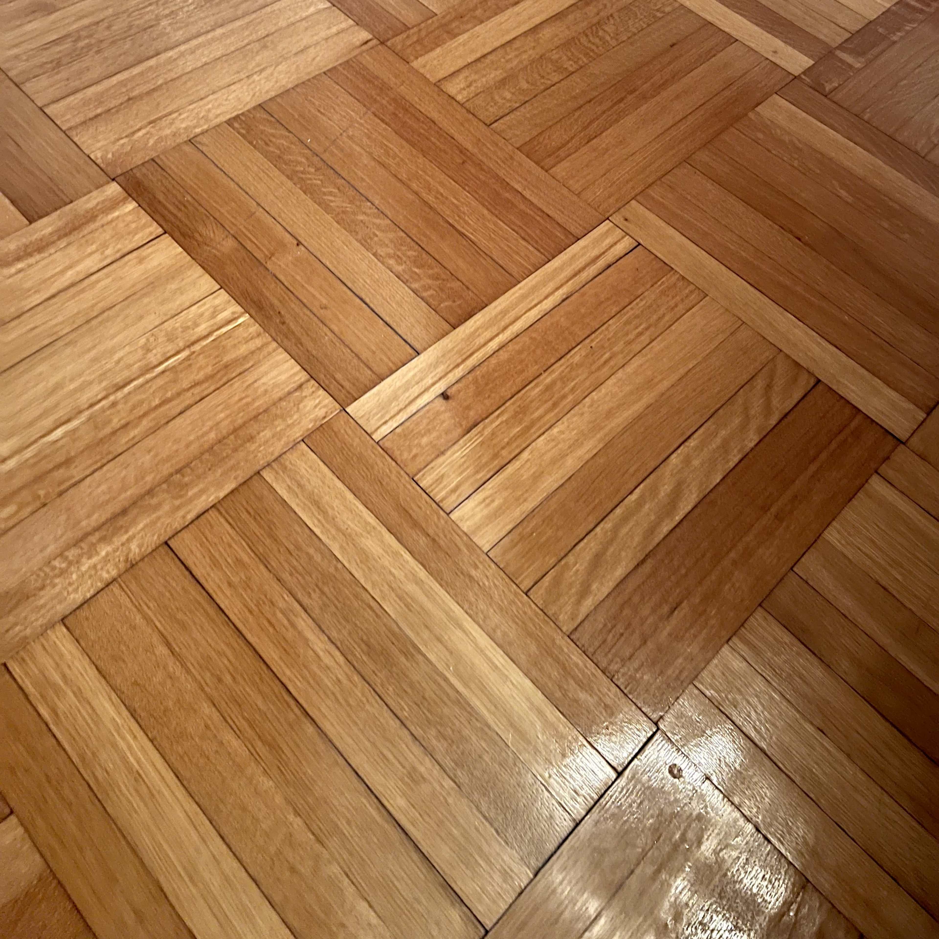 A section of wooden parquet flooring arranged in a geometric pattern.