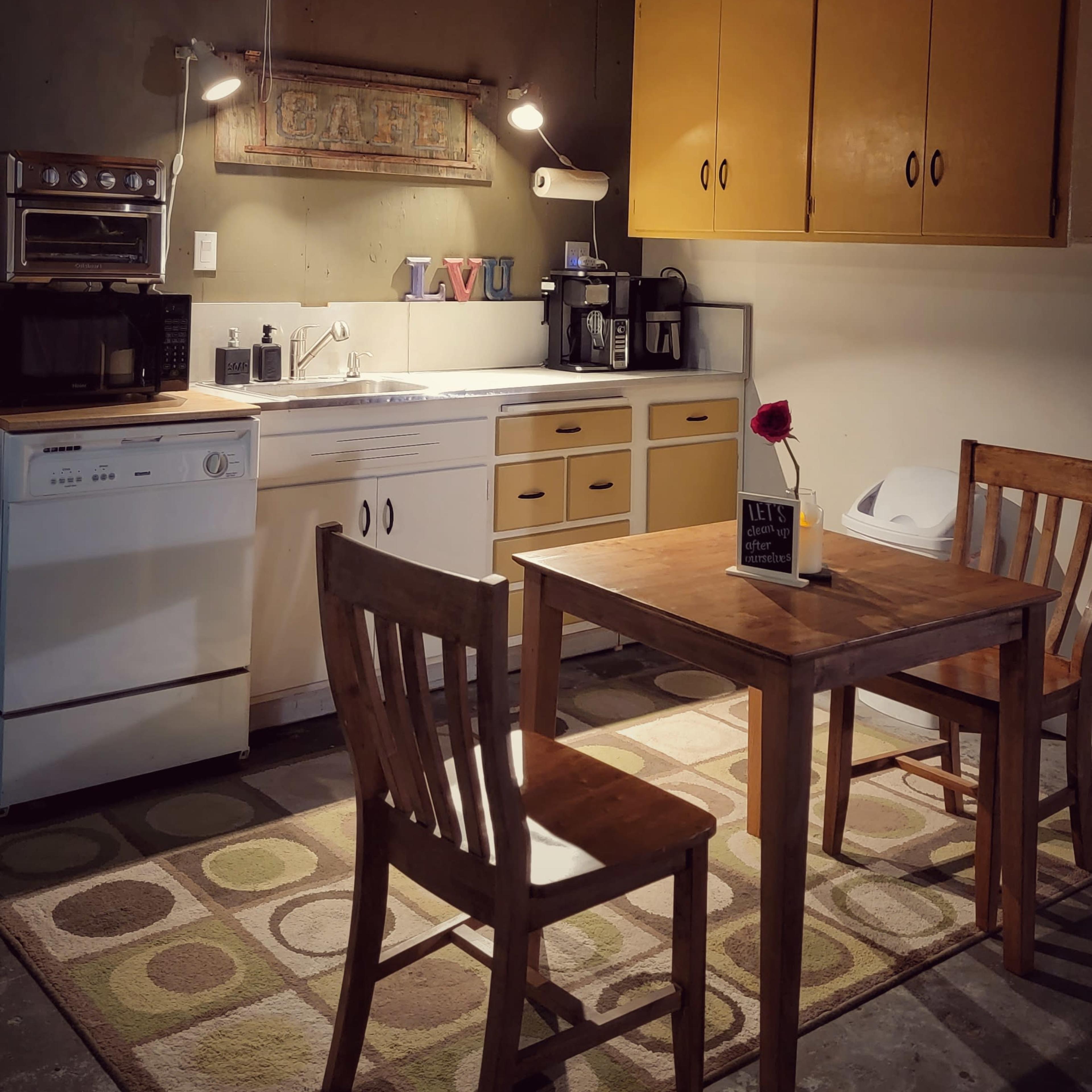 The scene features a photography studio with a backdrop setup, lighting equipment, and a desk near a wall adorned with decorative items.