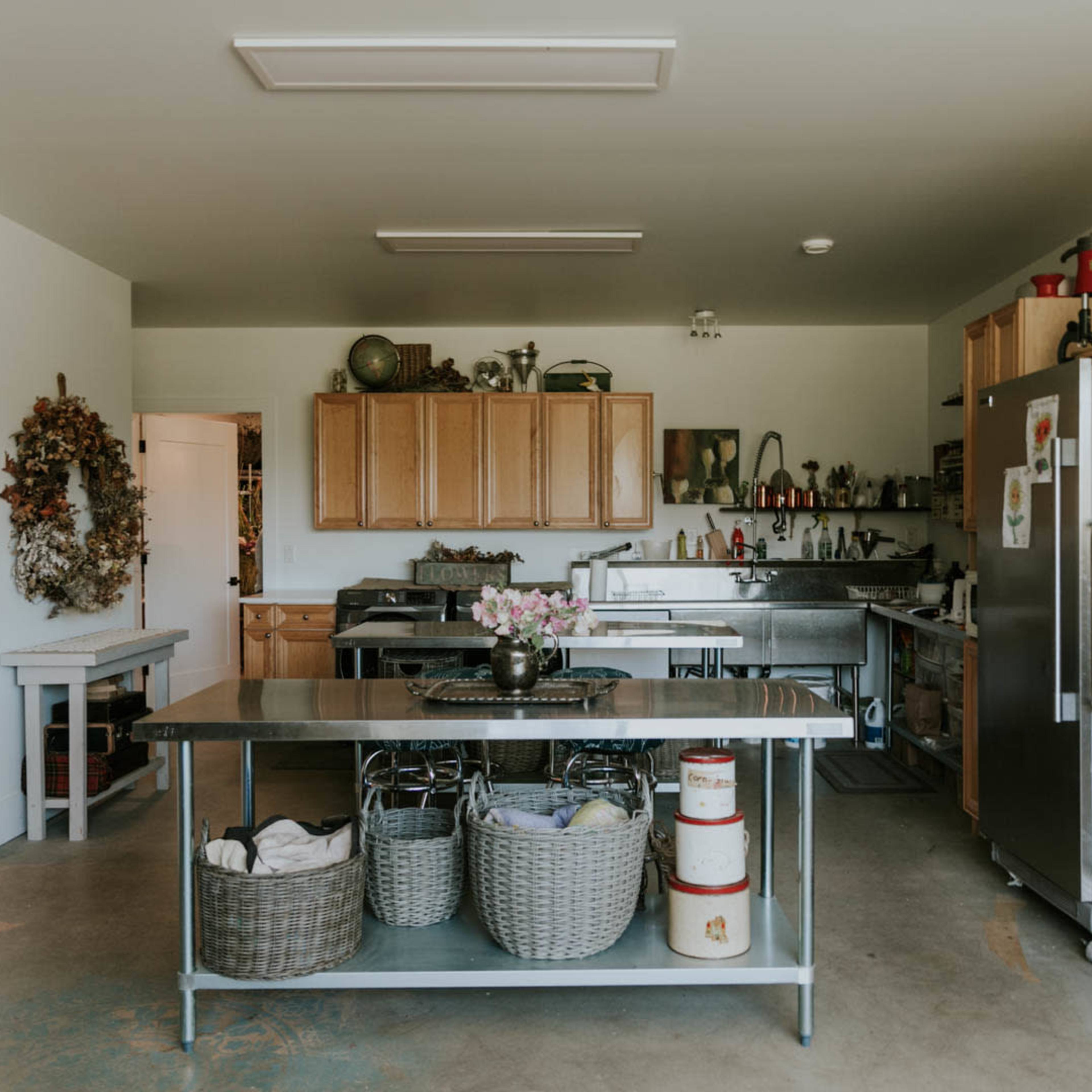 A spacious kitchen features wooden cabinets, stainless steel appliances, and a central island with storage baskets.