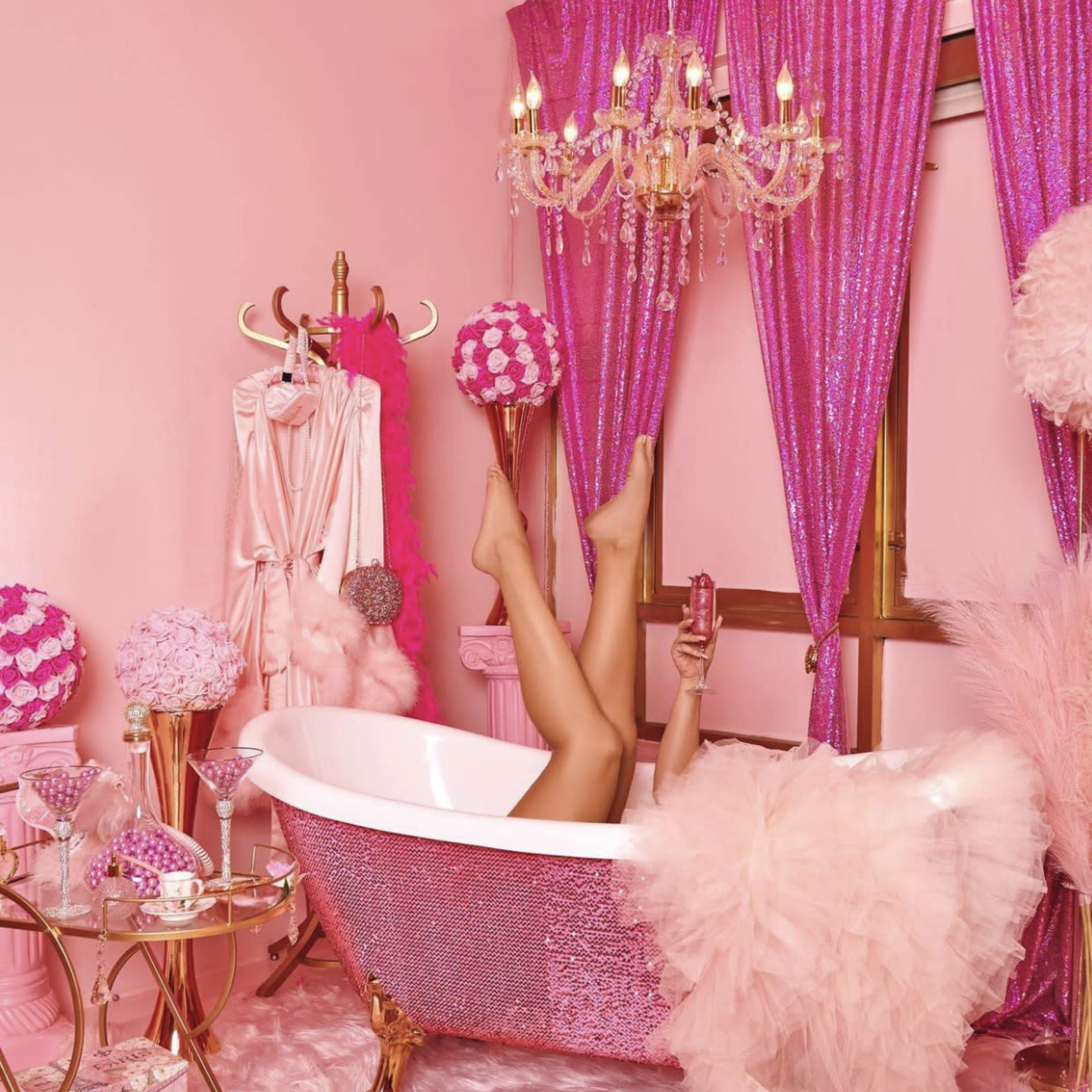 Eight women posed in various settings, all adorned in vibrant pink outfits, surrounded by pink decor and props.