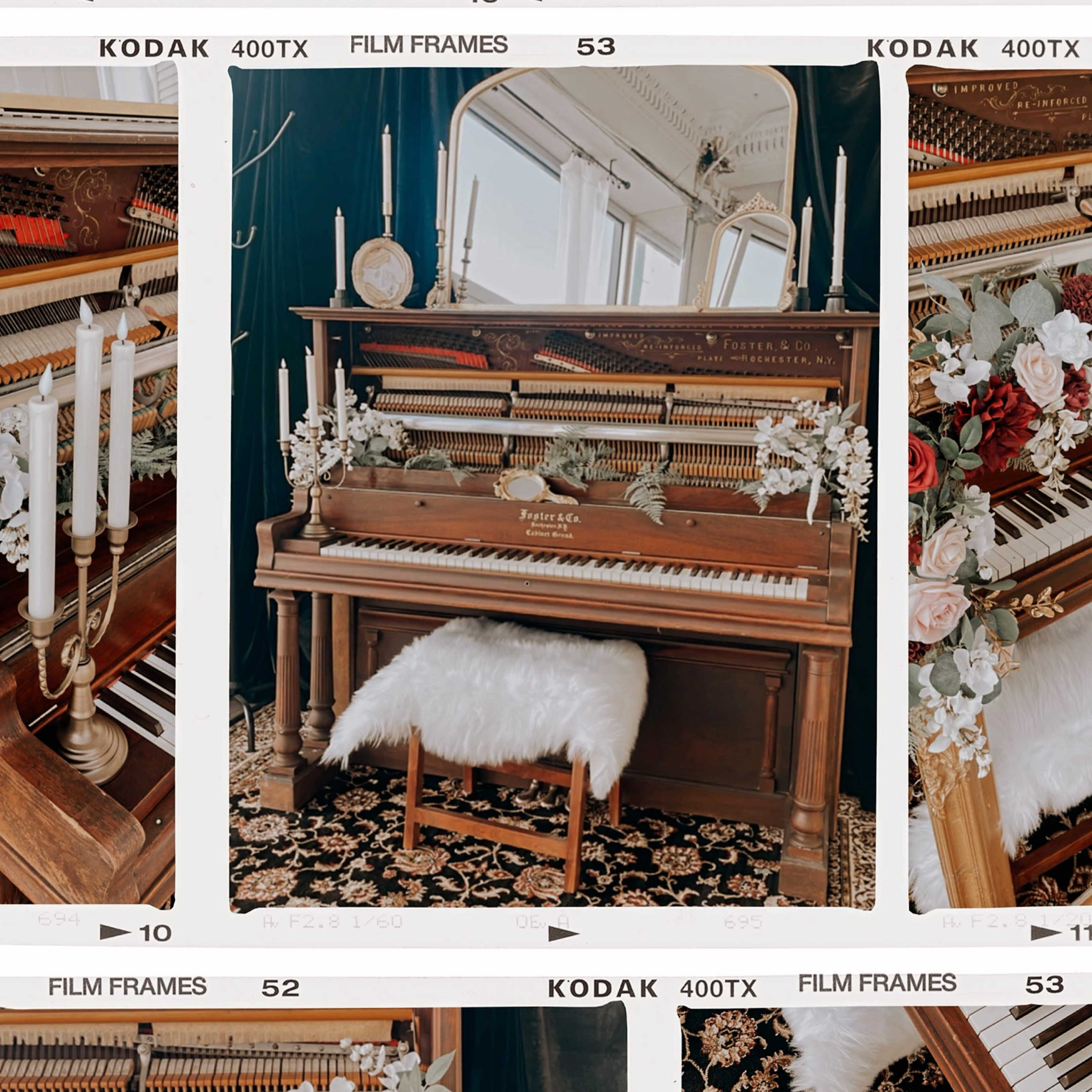 A vintage piano adorned with candles and decorative flowers, placed against a backdrop of a mirror and an ornate chair in a well-lit room.