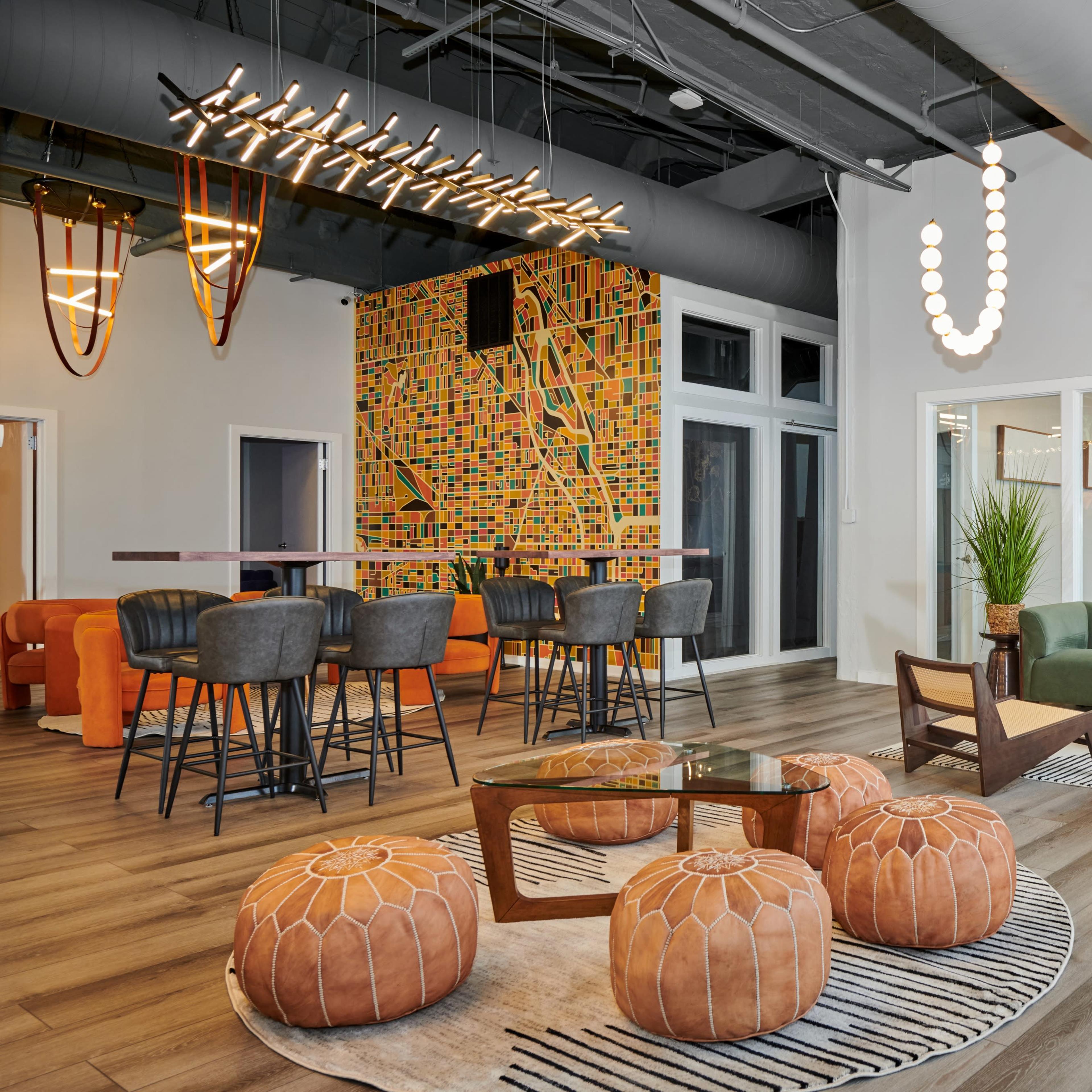A modern lounge area with a mix of seating, decorative lighting, and vibrant wall art.
