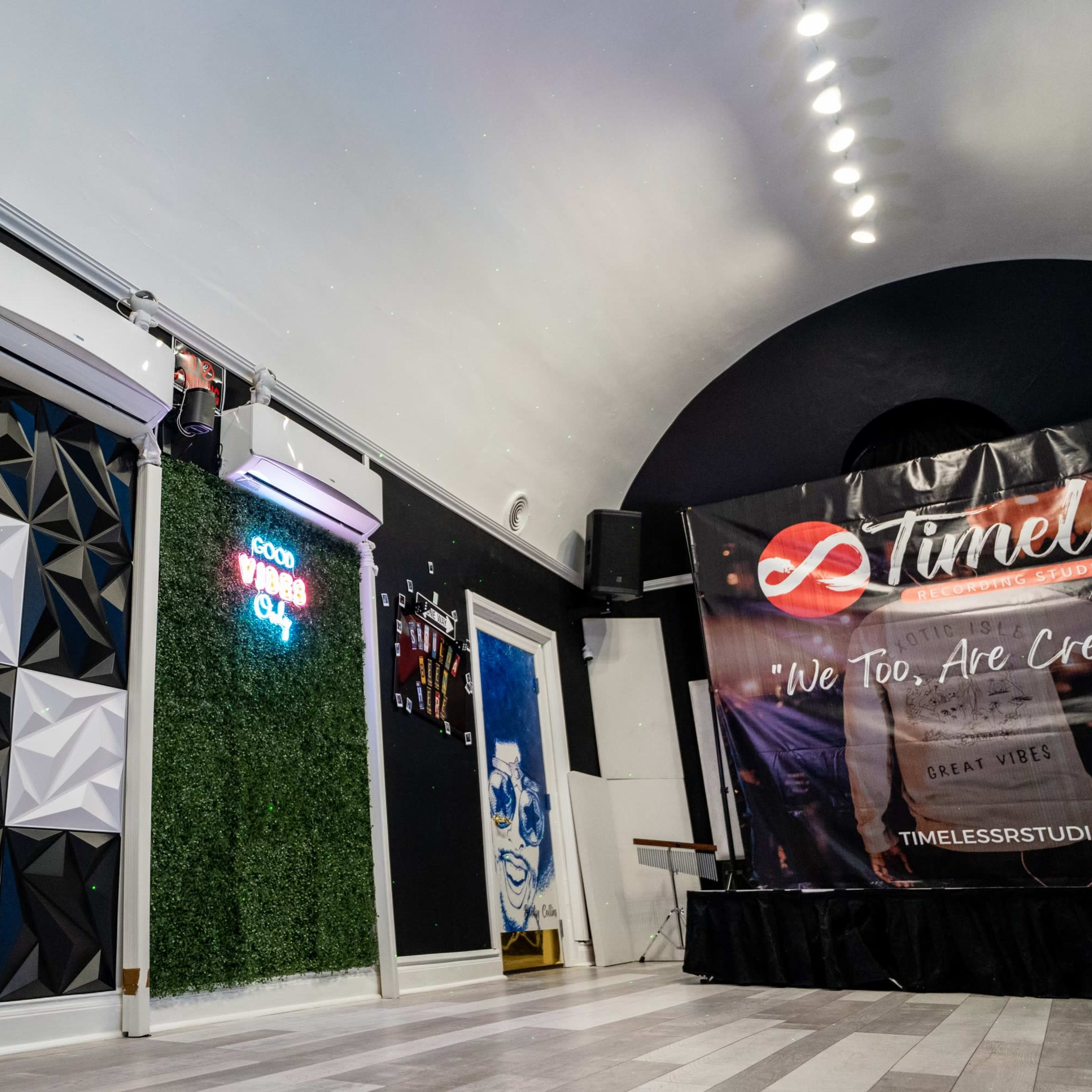 A modern interior space featuring a geometric wall panel, air conditioning units, neon signage, and a promotional banner.