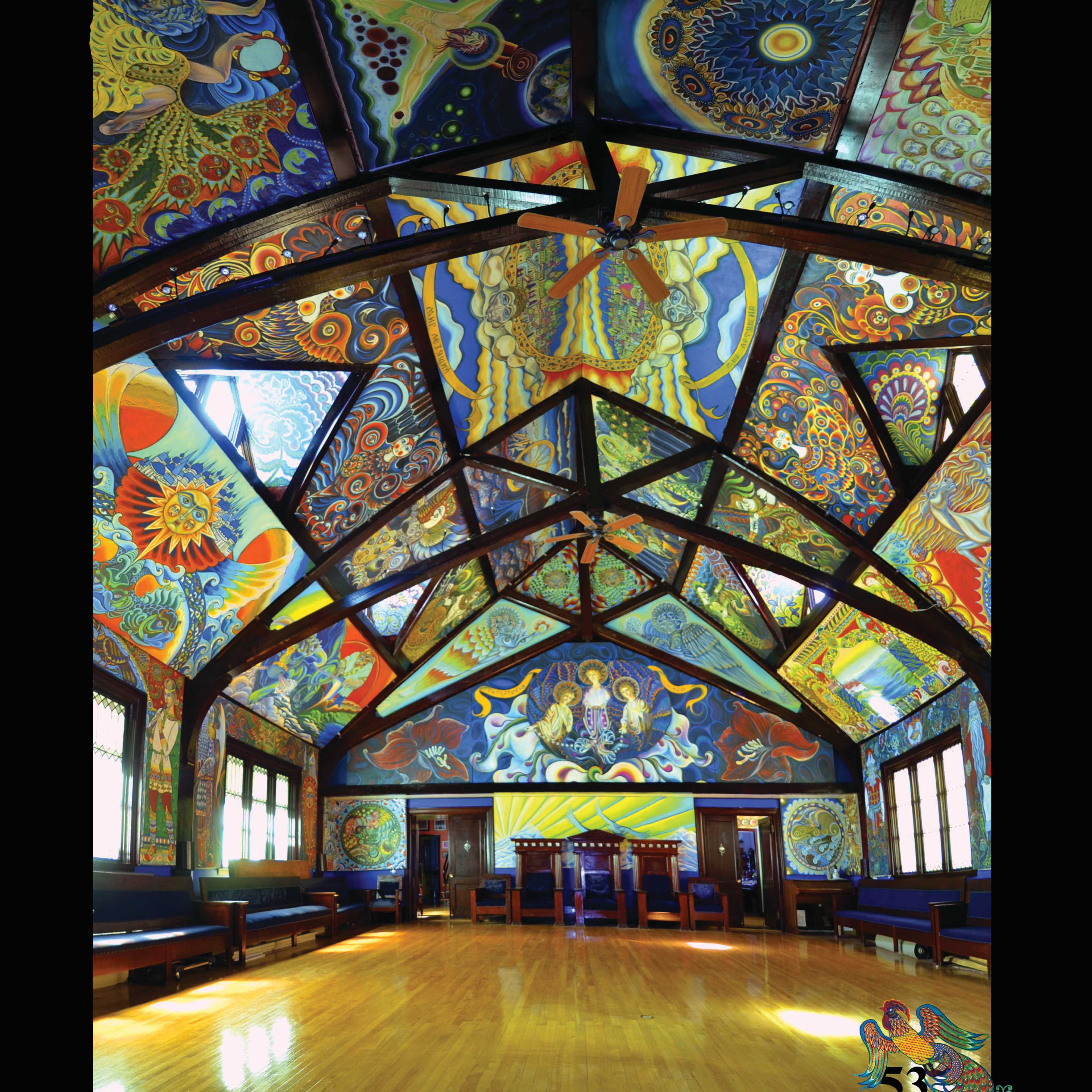 A large room with colorful murals covering the ceiling and walls, featuring intricate patterns and designs.
