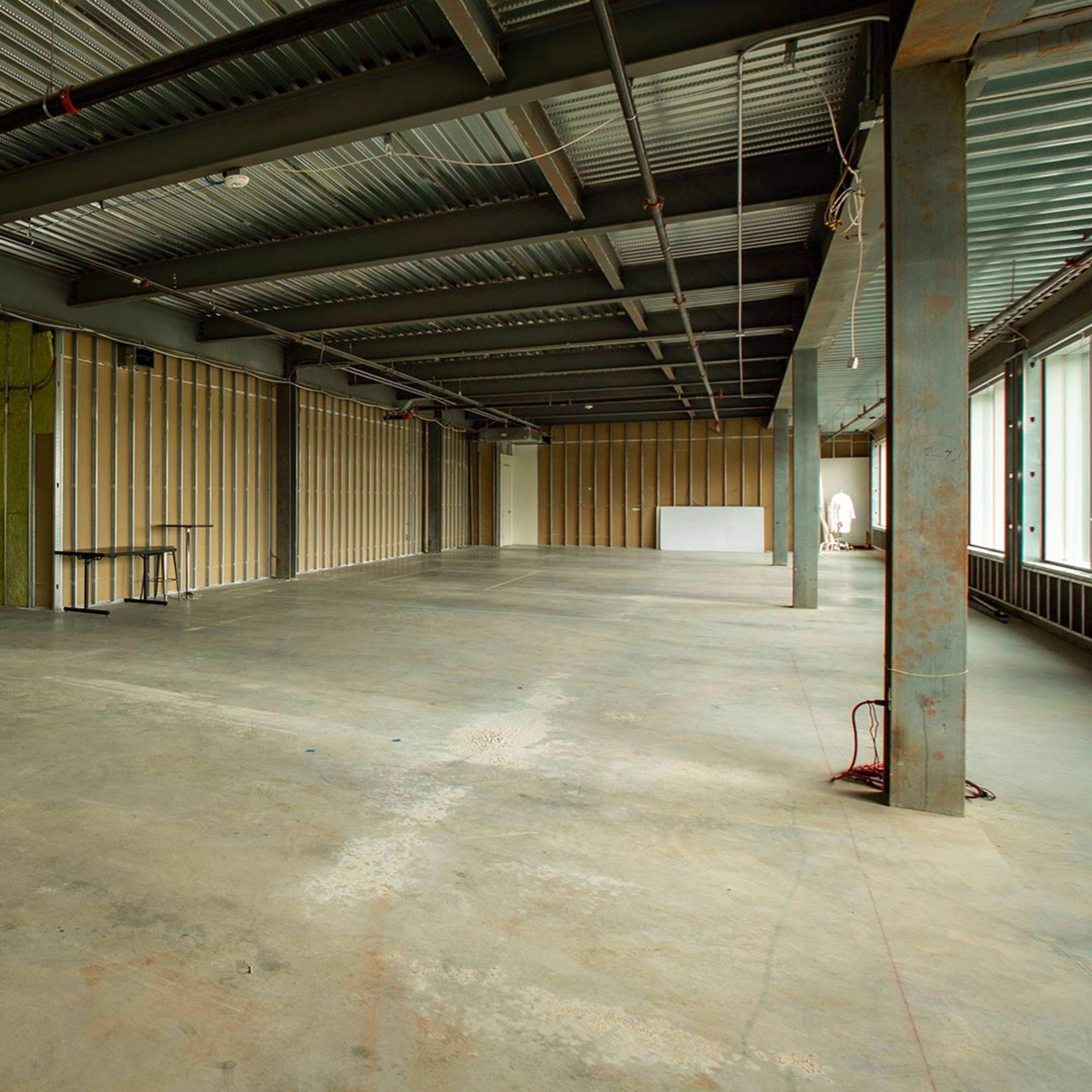 An empty, unfinished indoor space with exposed walls and concrete flooring.