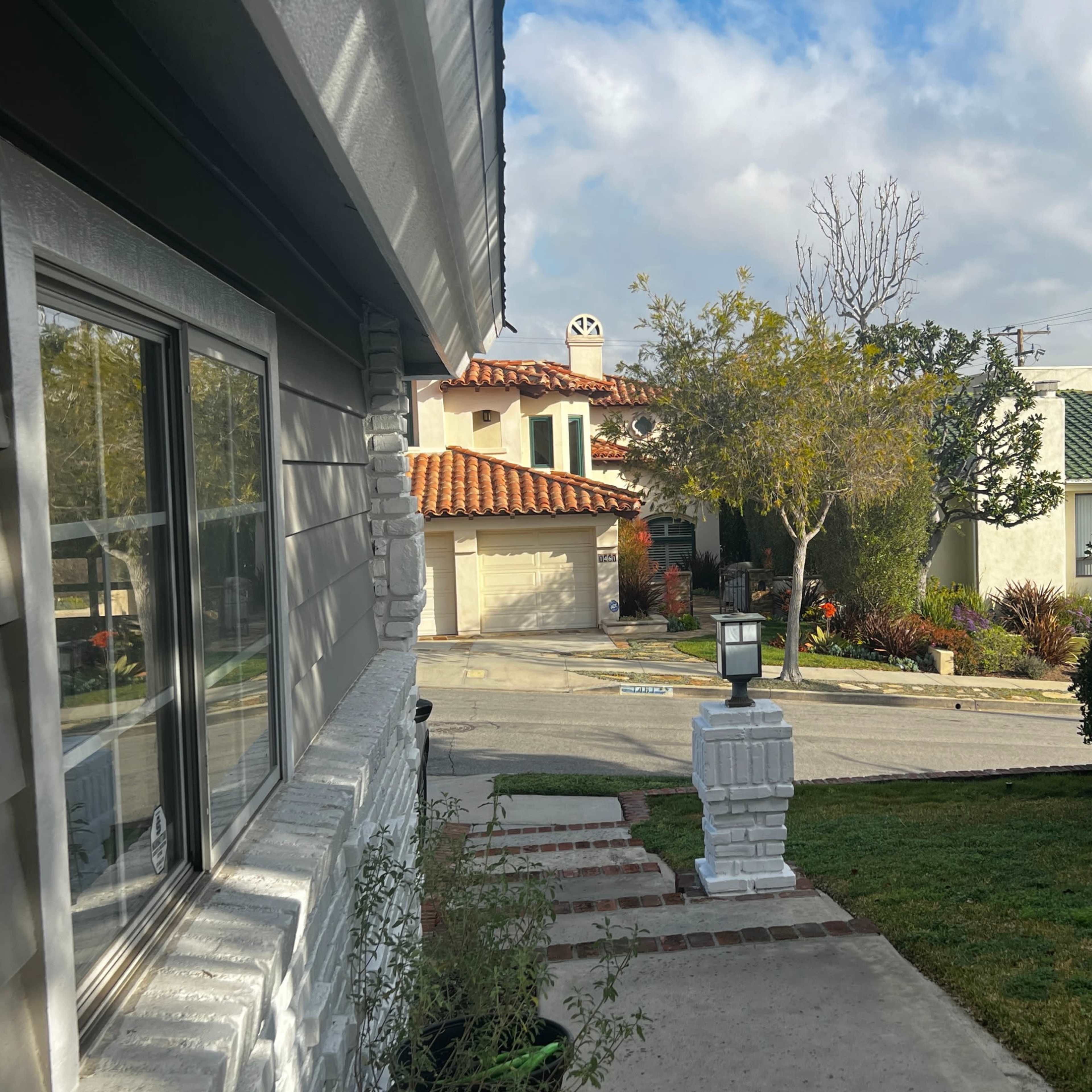 A residential neighborhood with a view of houses, a mailbox at the forefront, and cloudy skies above.