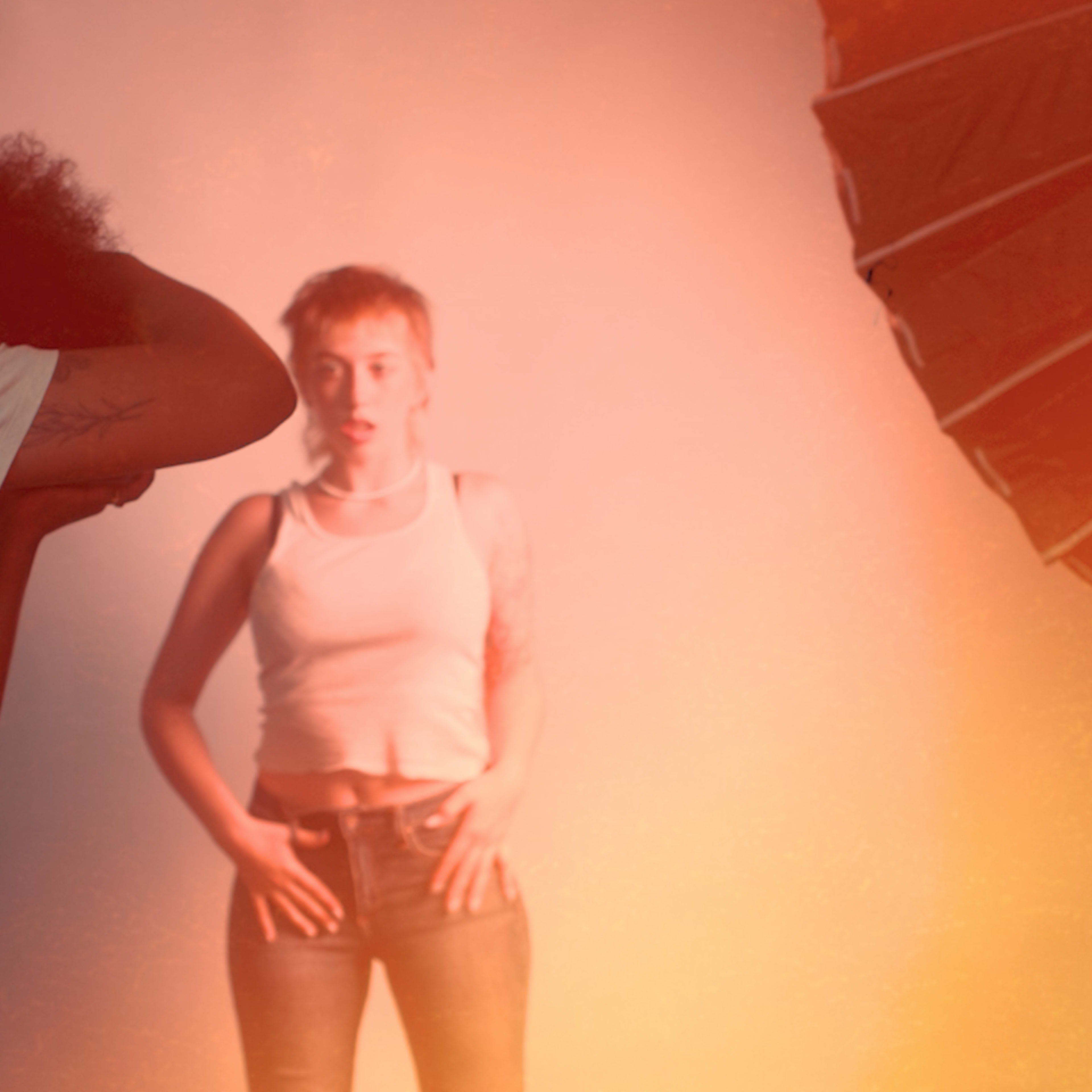 A photographer captures a model in front of a brightly lit backdrop while using large softbox lights.