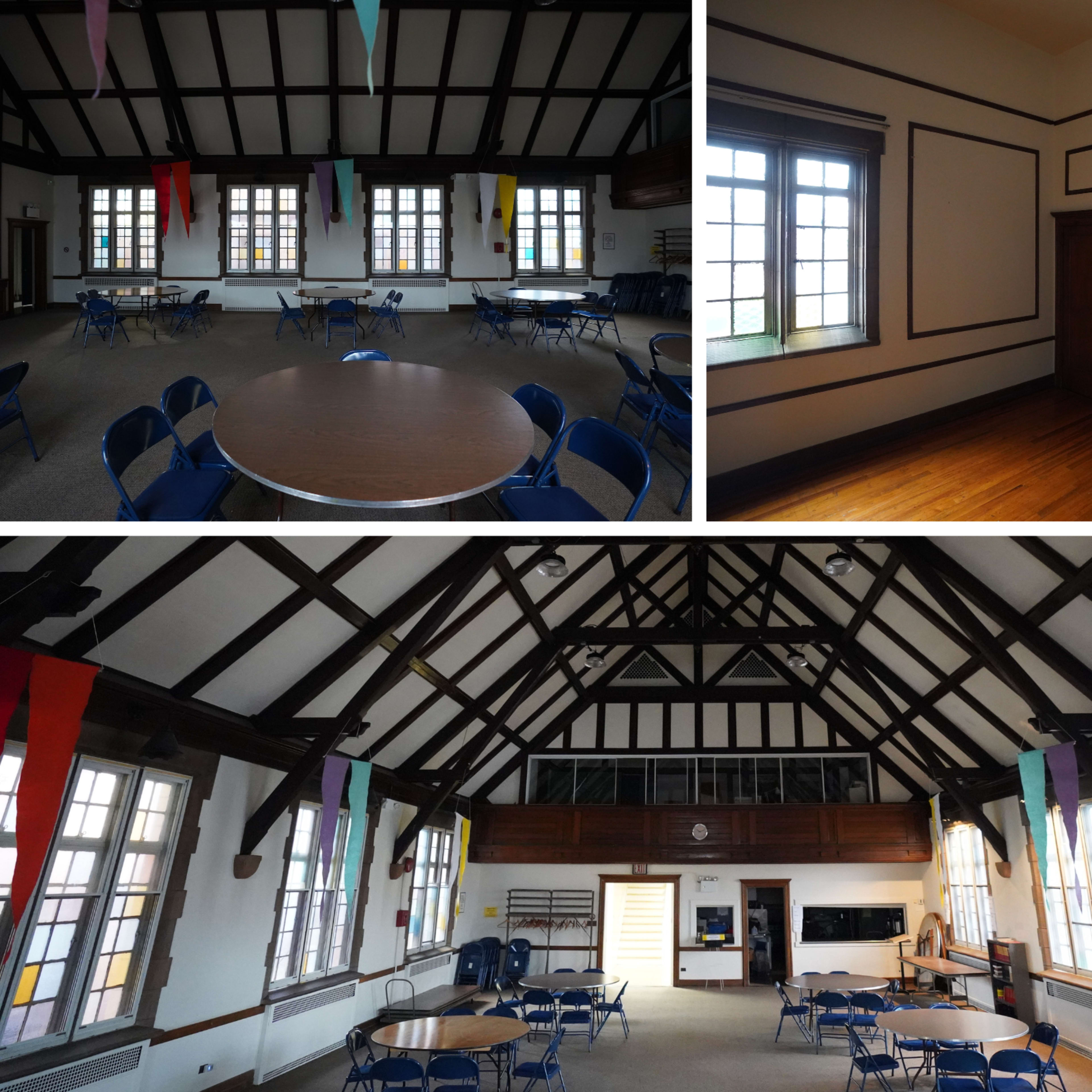 A spacious room with high ceilings, wooden beams, and several round tables surrounded by blue chairs.