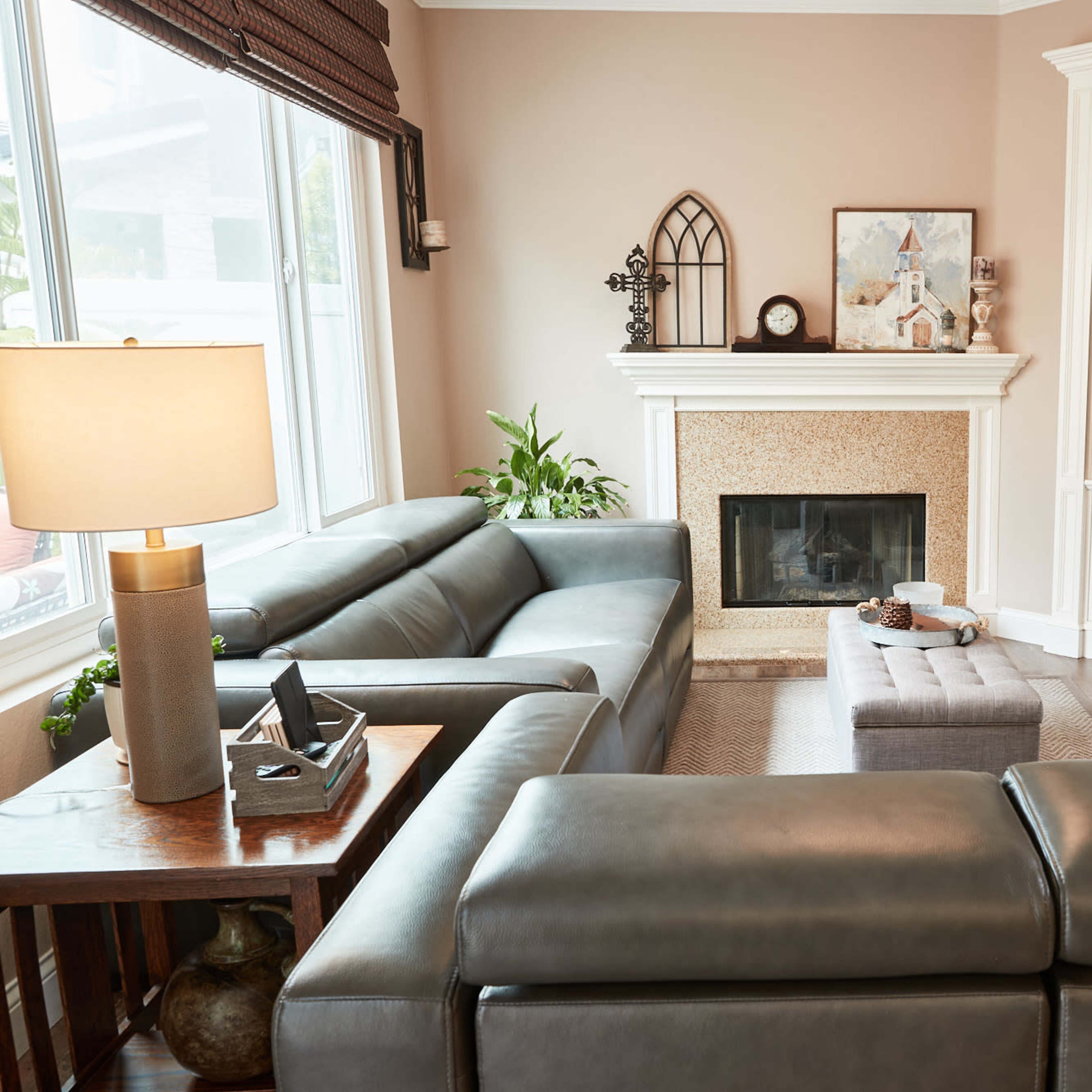 A modern living room features a large sectional sofa, a decorative fireplace, a built-in TV unit, and a coffee table in a cozy arrangement.