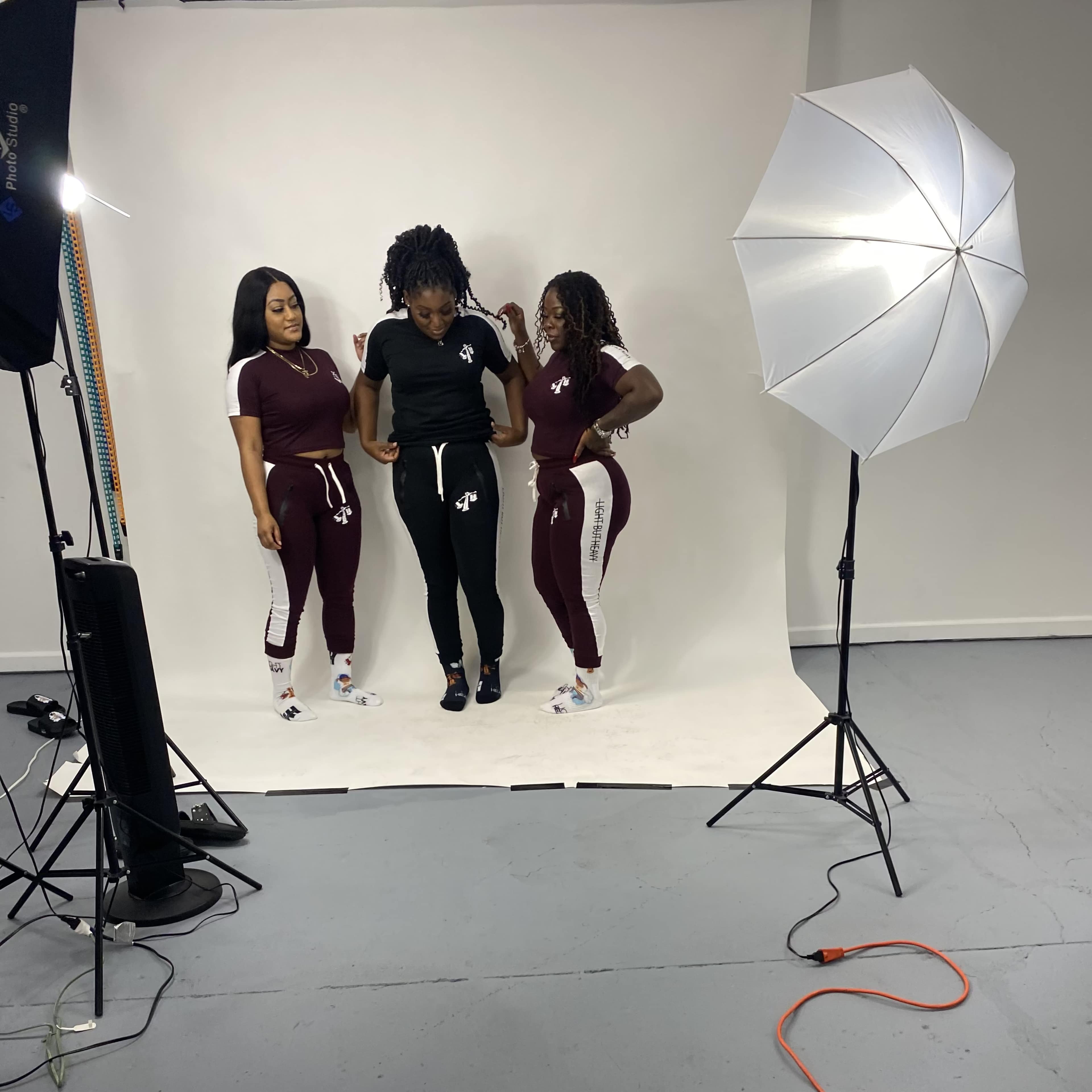 Three women pose in athletic wear in a well-lit studio setting.