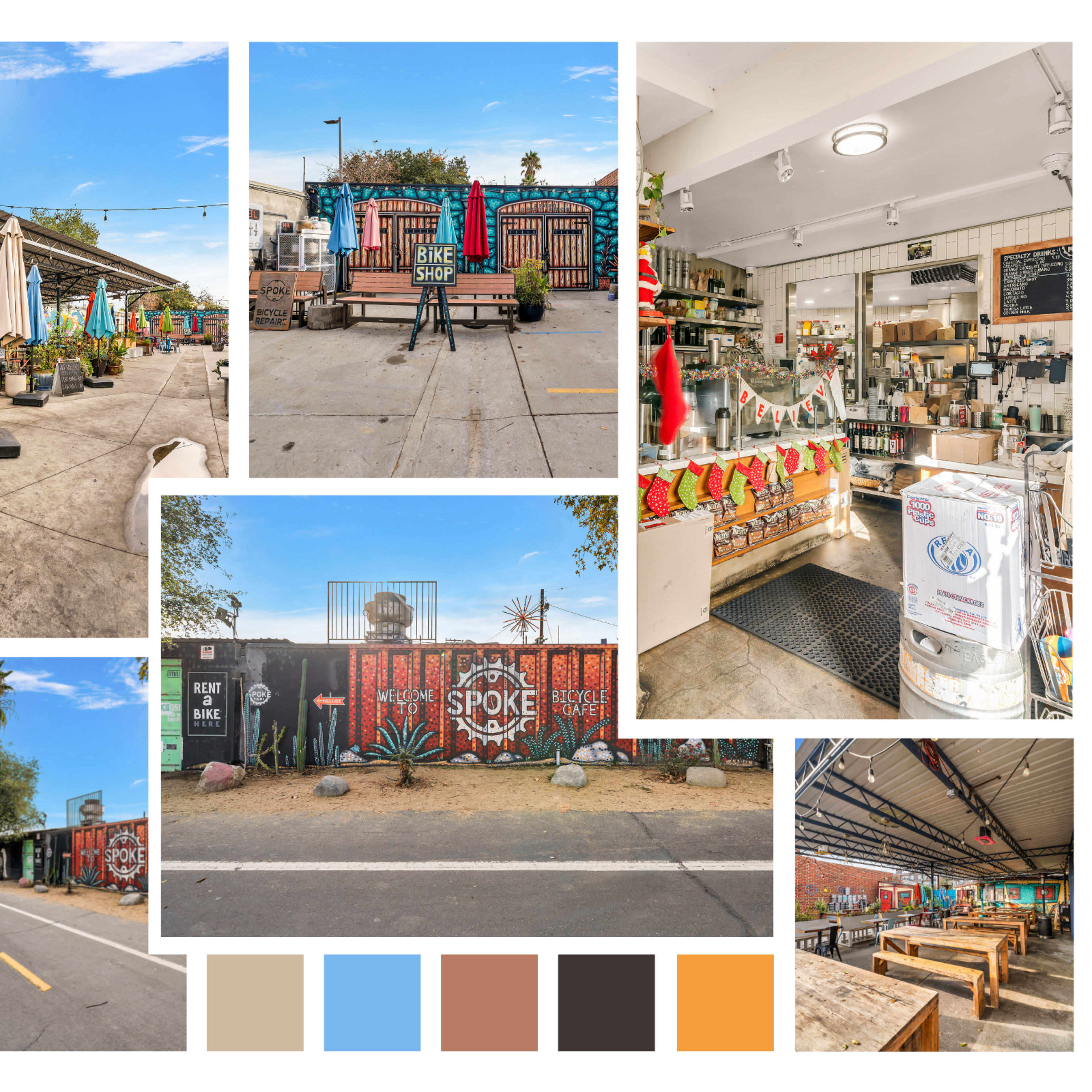 A vibrant outdoor market area featuring colorful umbrellas, mural-adorned walls, and distinct vendor spaces.