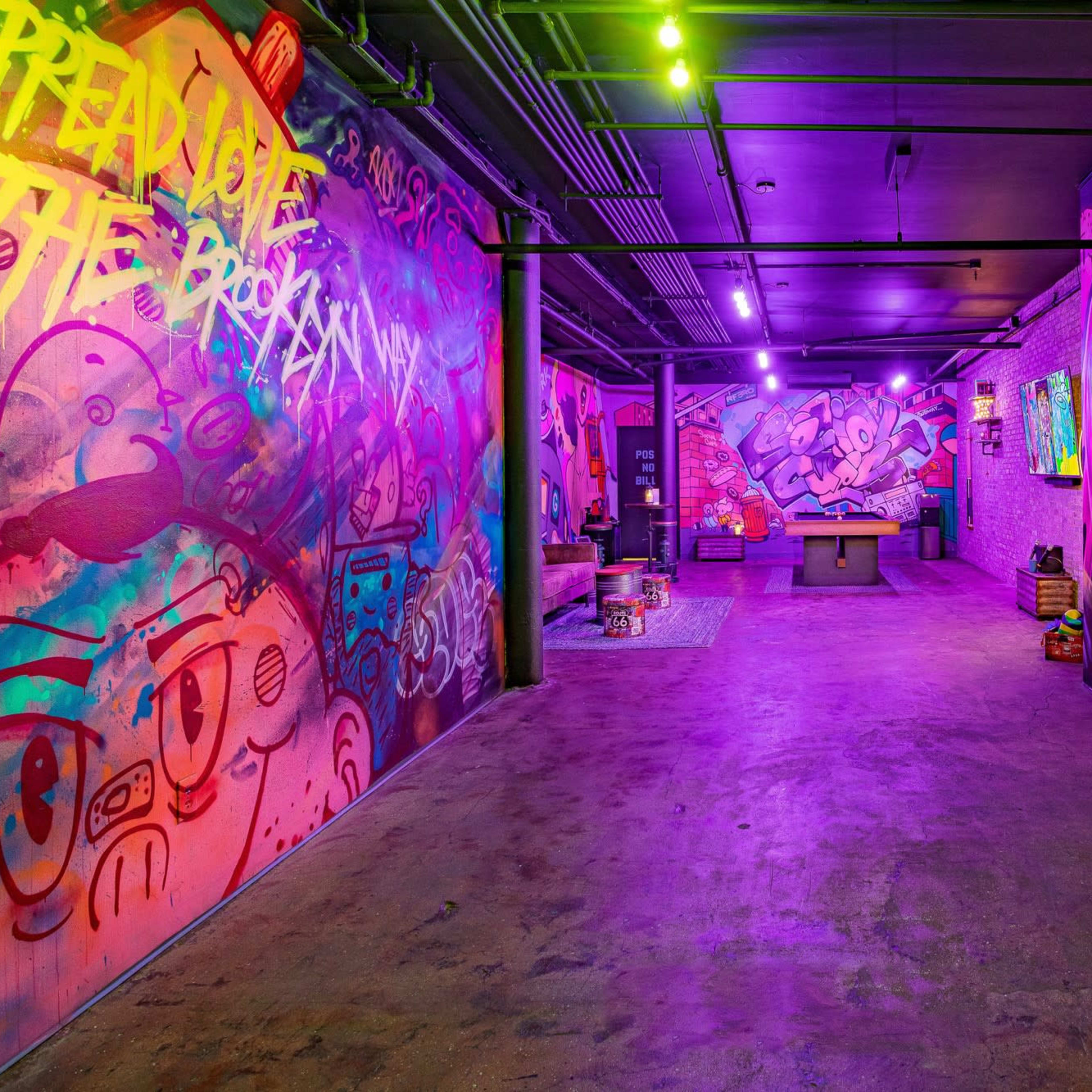 The scene features a vibrant indoor space with graffiti-covered walls, colorful lighting, and a pool table in the center.