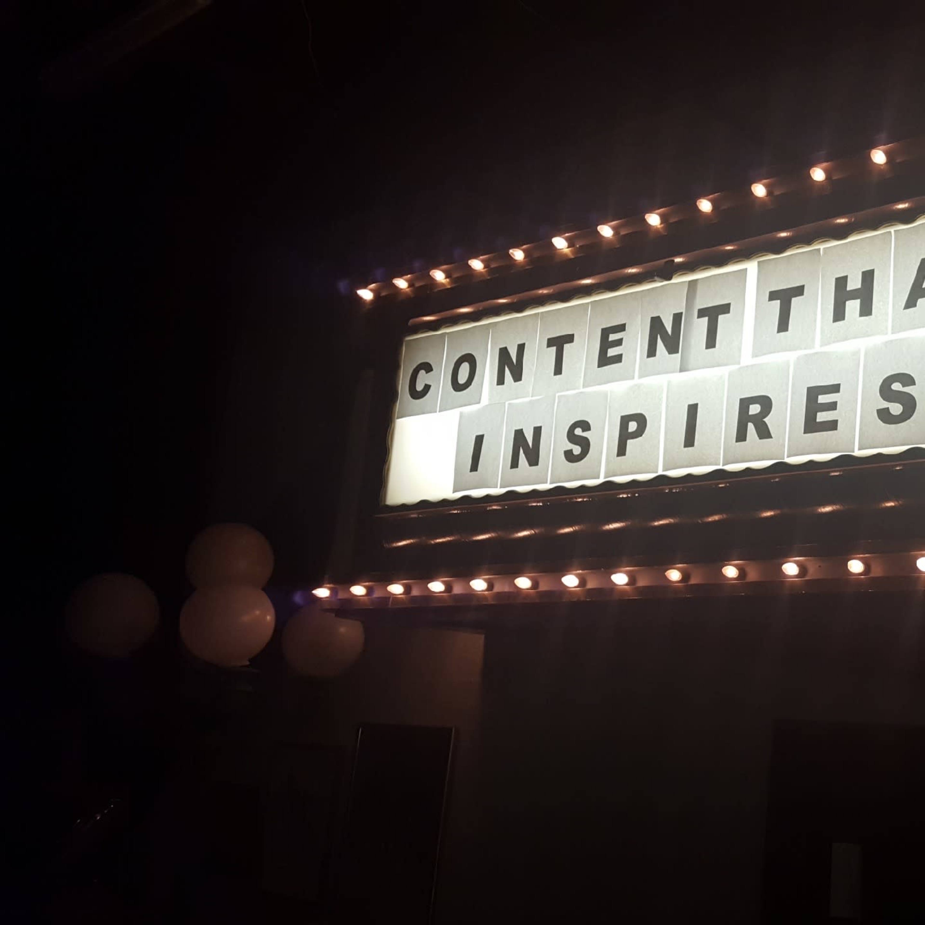 A marquee sign displays the phrase "CONTENT THAT INSPIRES" illuminated by lights.