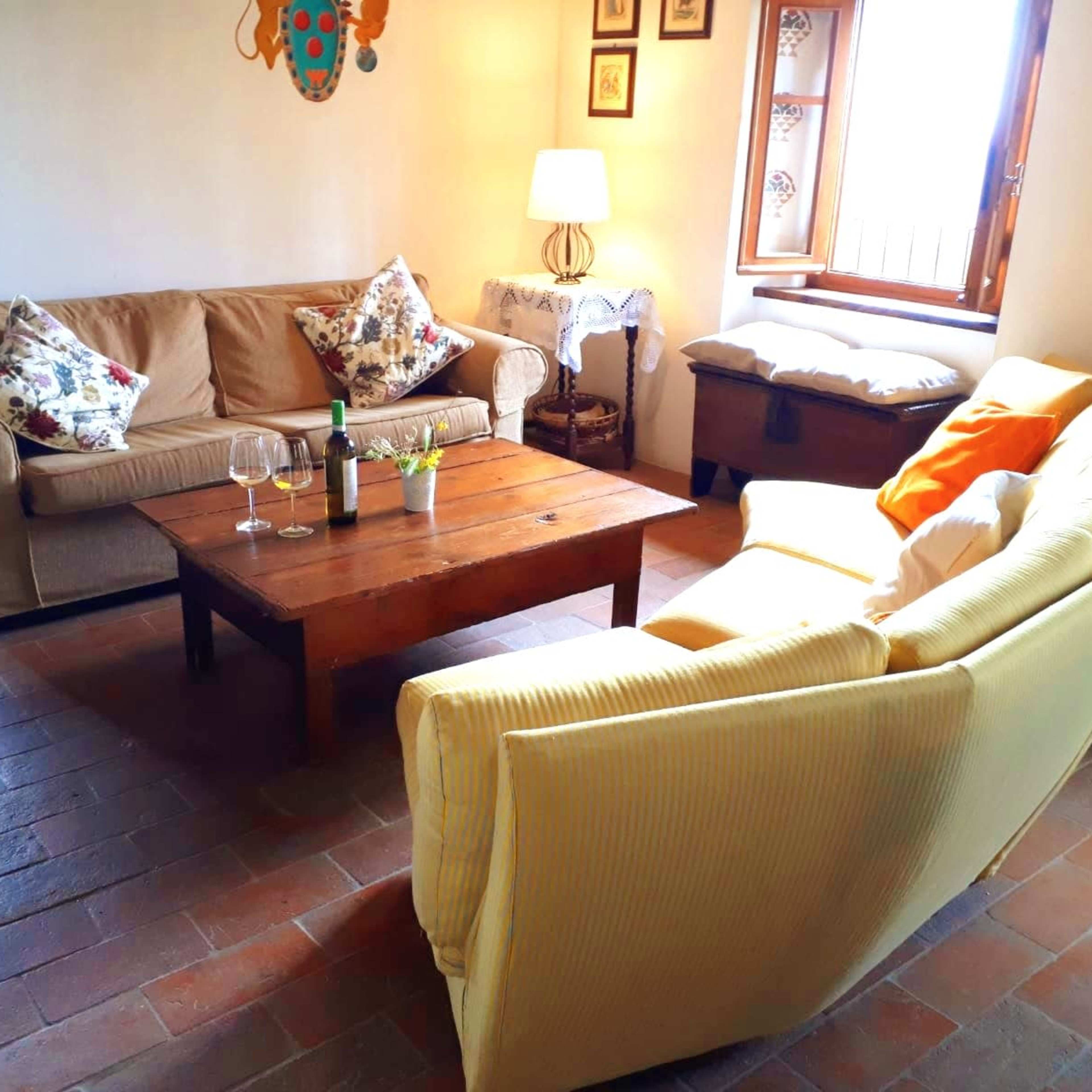 A living room with two sofas, a wooden coffee table, and a window with natural light.