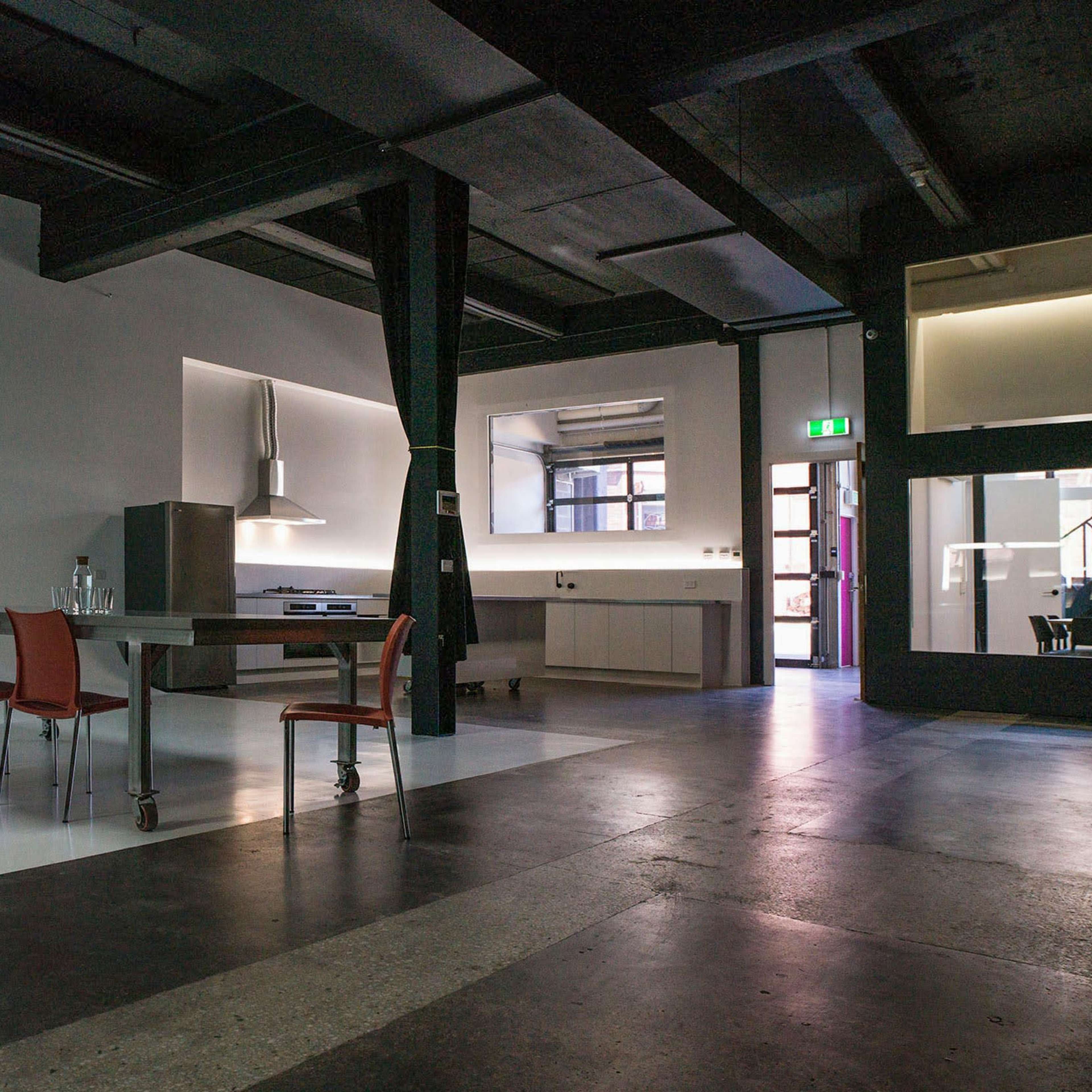 A modern kitchen and dining area are shown with a table and chairs, featuring a projection on the wall displaying images from a website.