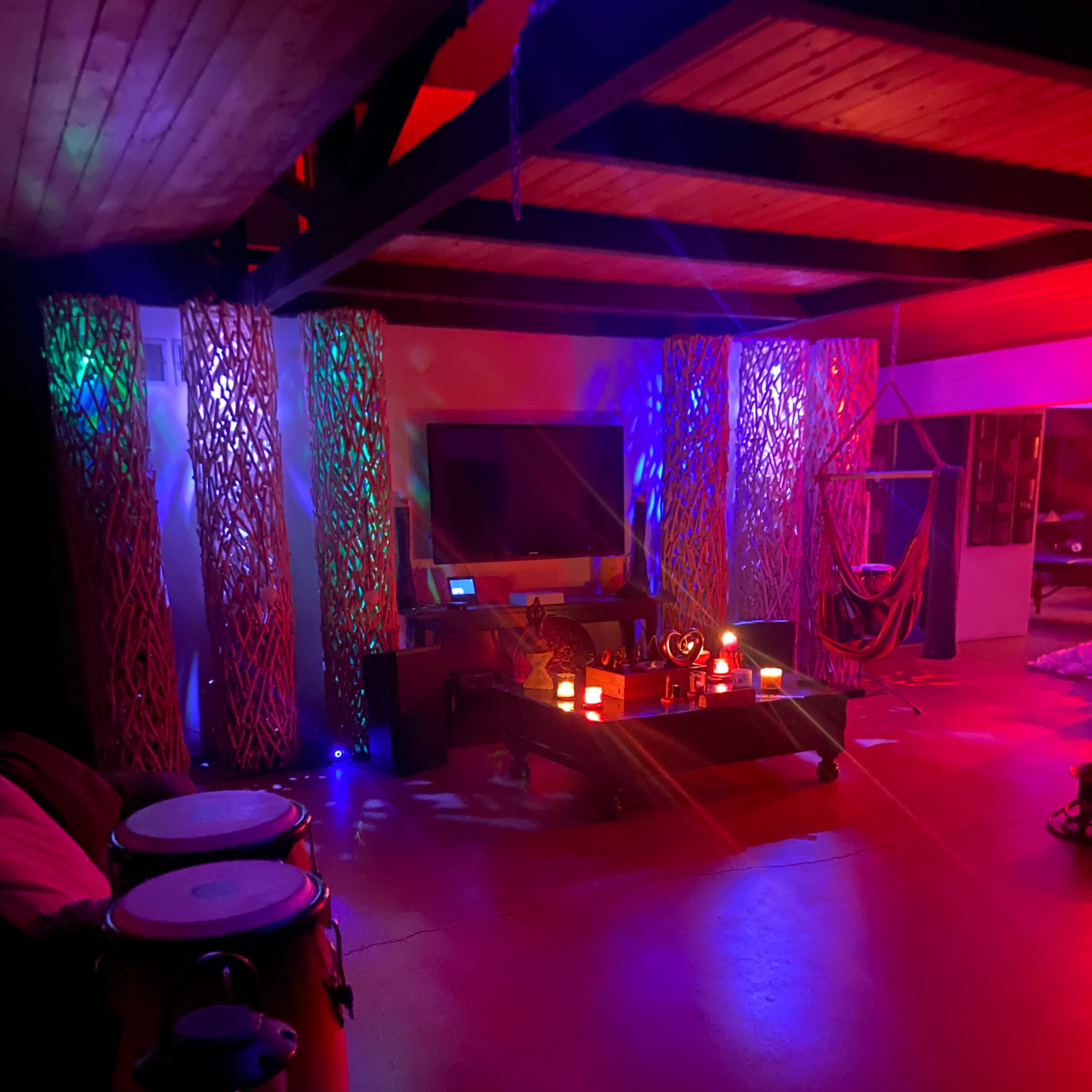 The scene features a dimly lit room with colorful lighting effects, decorated with illuminated panels and musical instruments displayed.