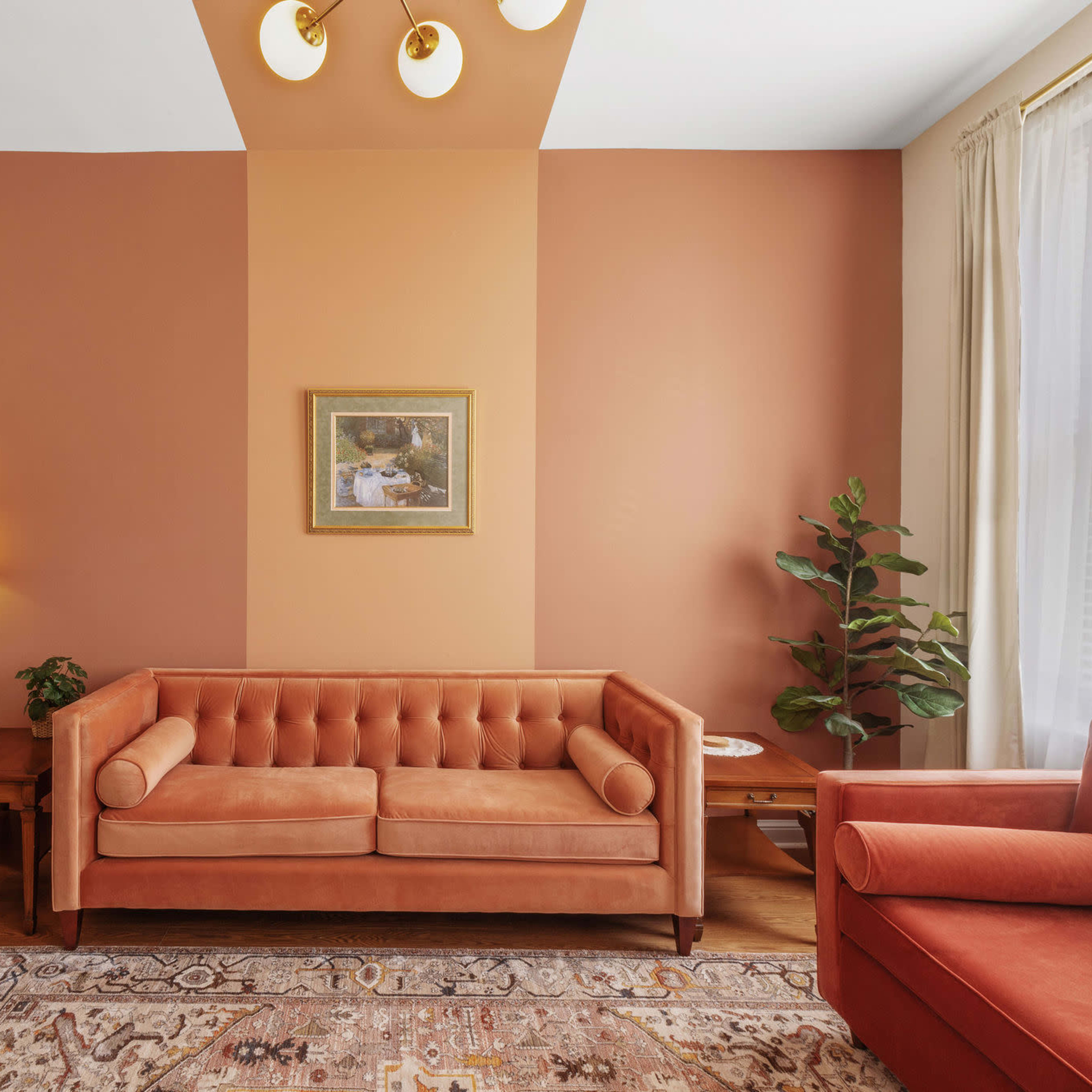 A living room with a sofa and armchair in warm tones, a painting on the wall, a floor lamp, and a potted plant.
