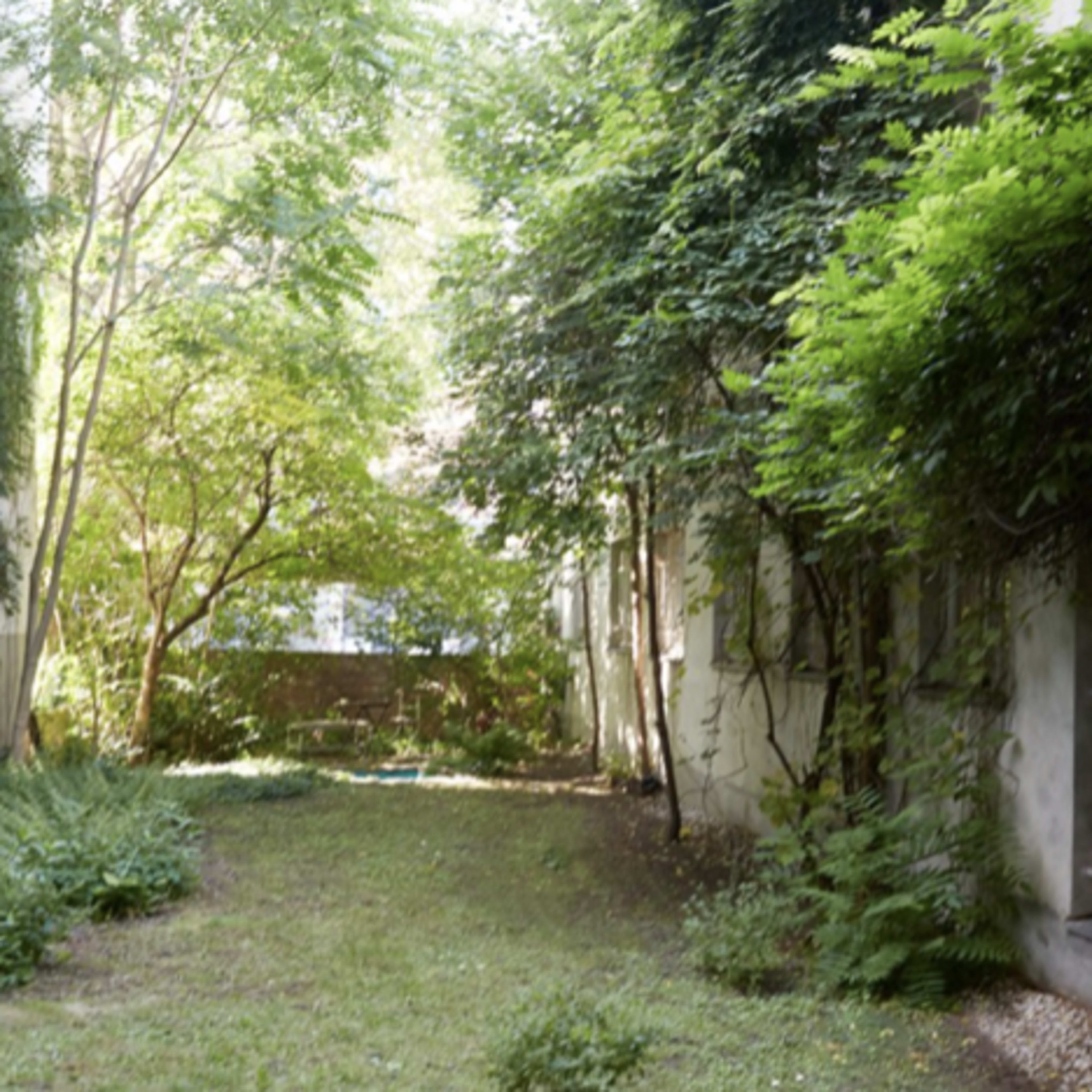 A narrow, green garden enclosed by tall walls covered in plants and trees.