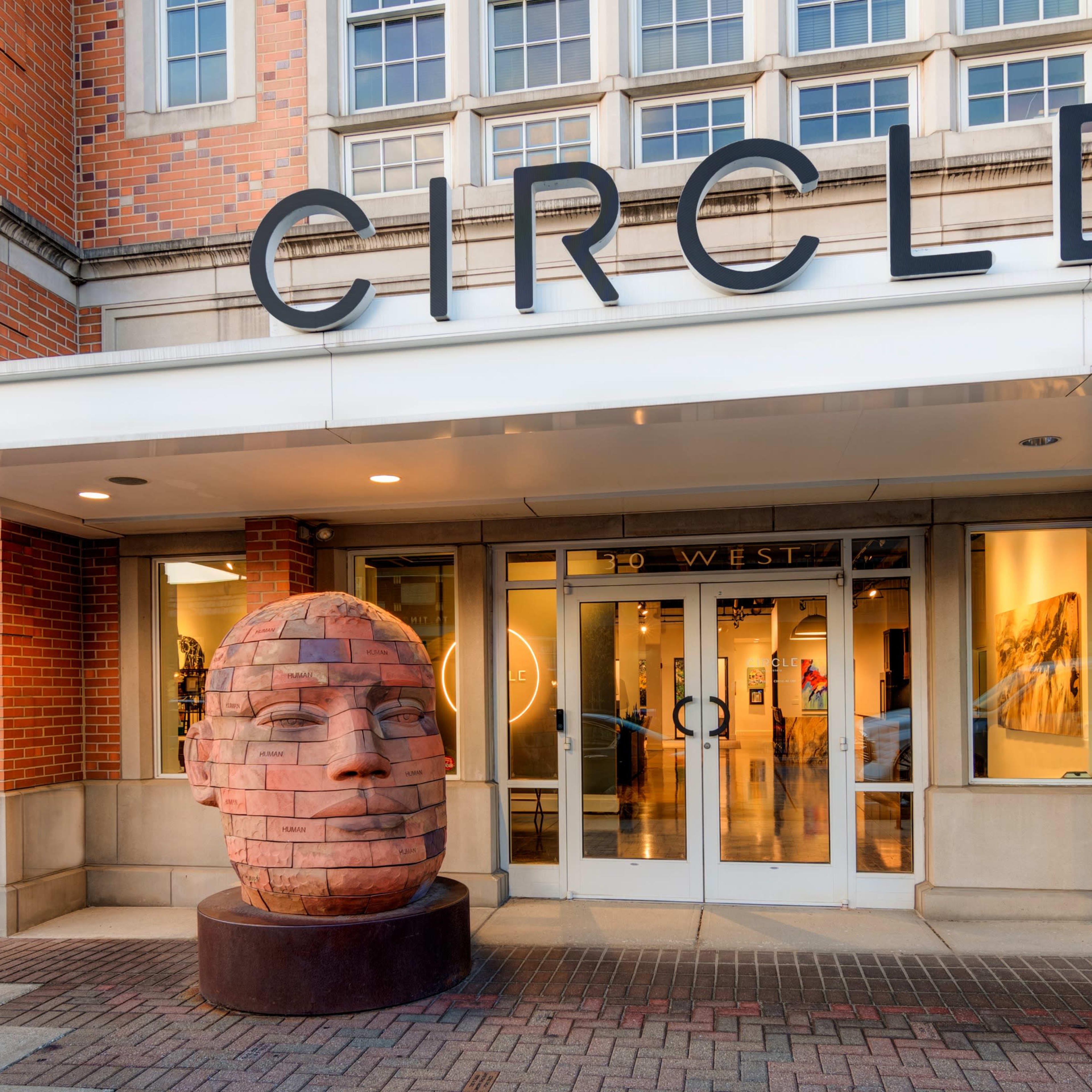The entrance of a building labeled "CIRCLE" features a large, sculpted head as a centerpiece.
