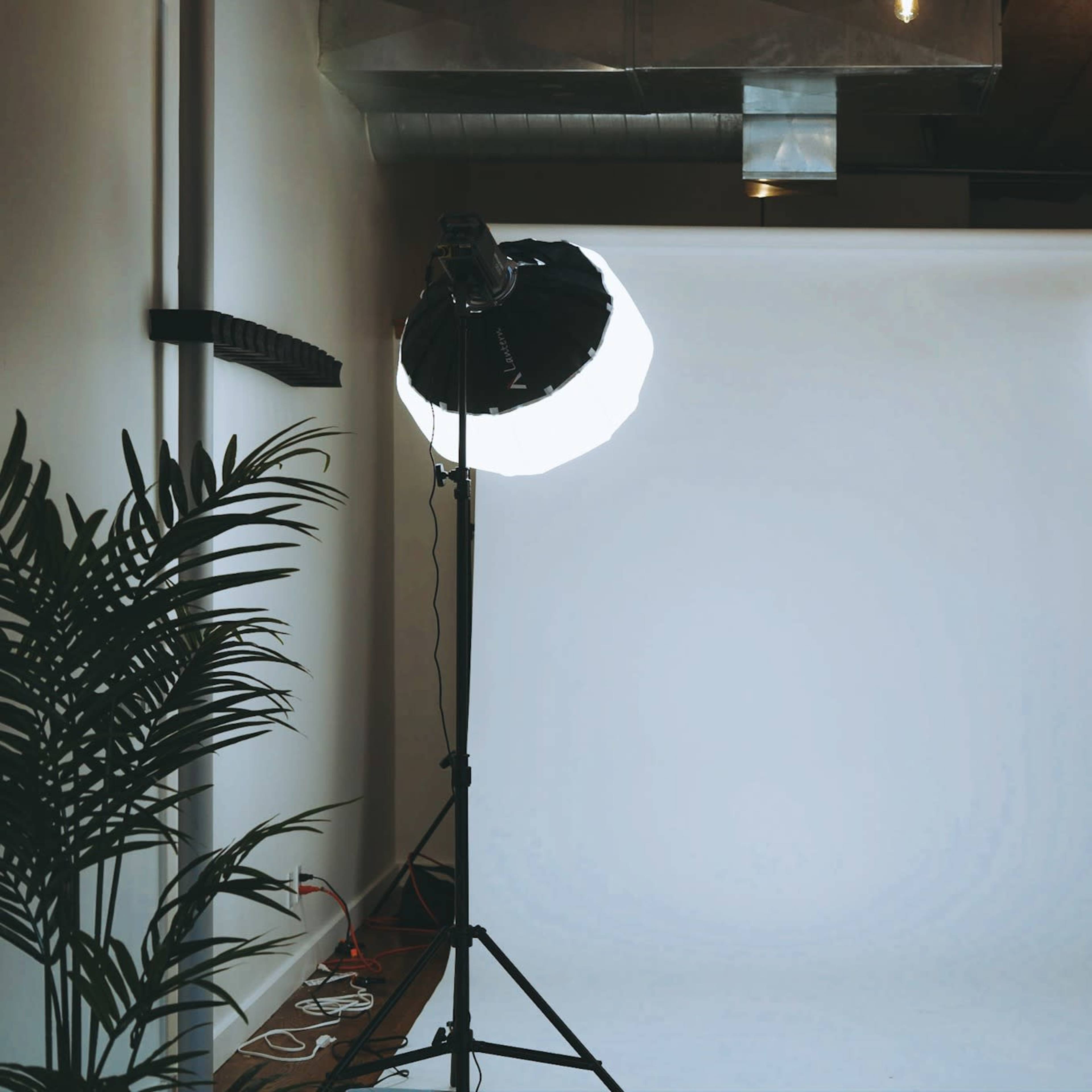 A photography studio setup with two light stands positioned in front of a white backdrop.