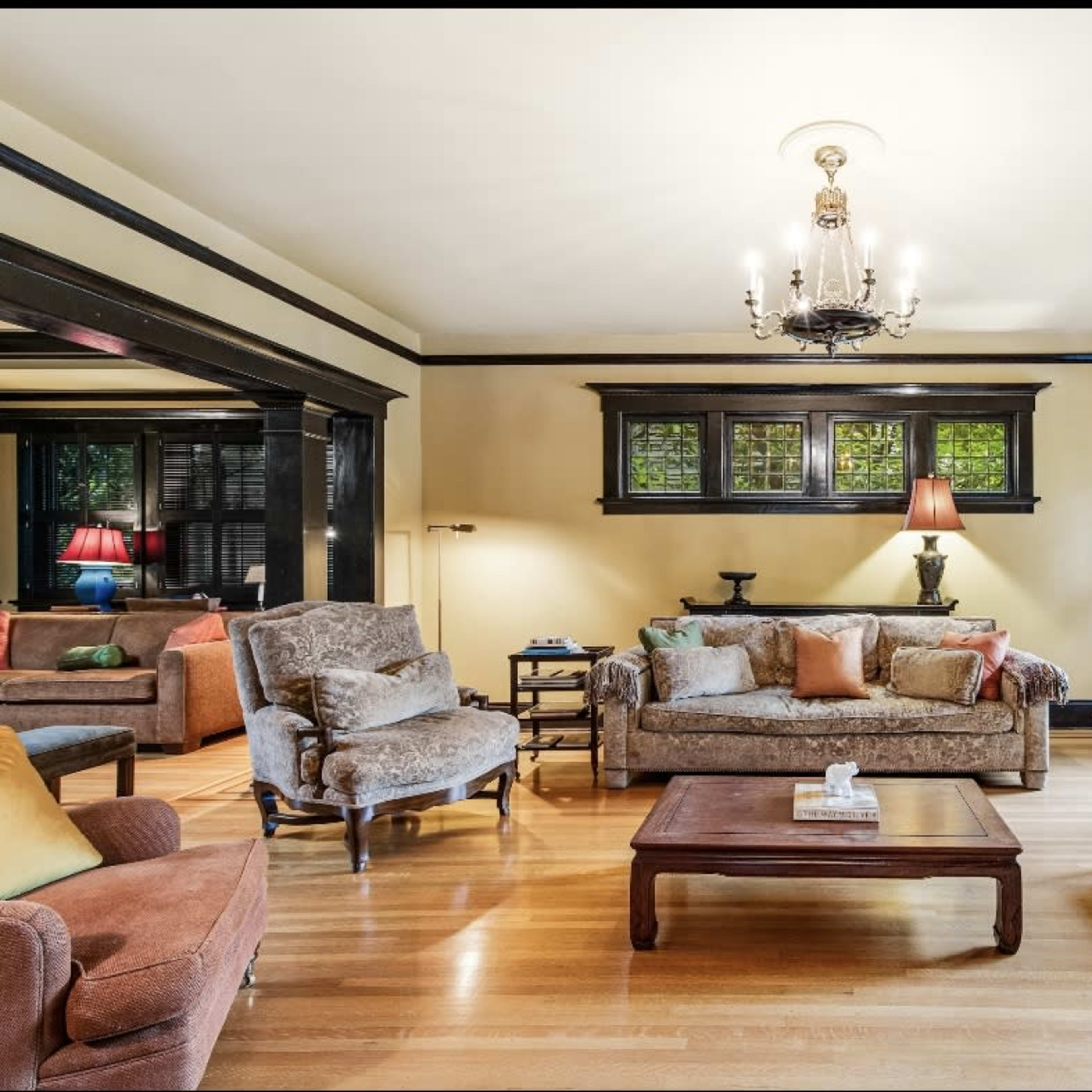 A spacious living room with a variety of seating options, a wooden coffee table, and large windows that let in natural light.