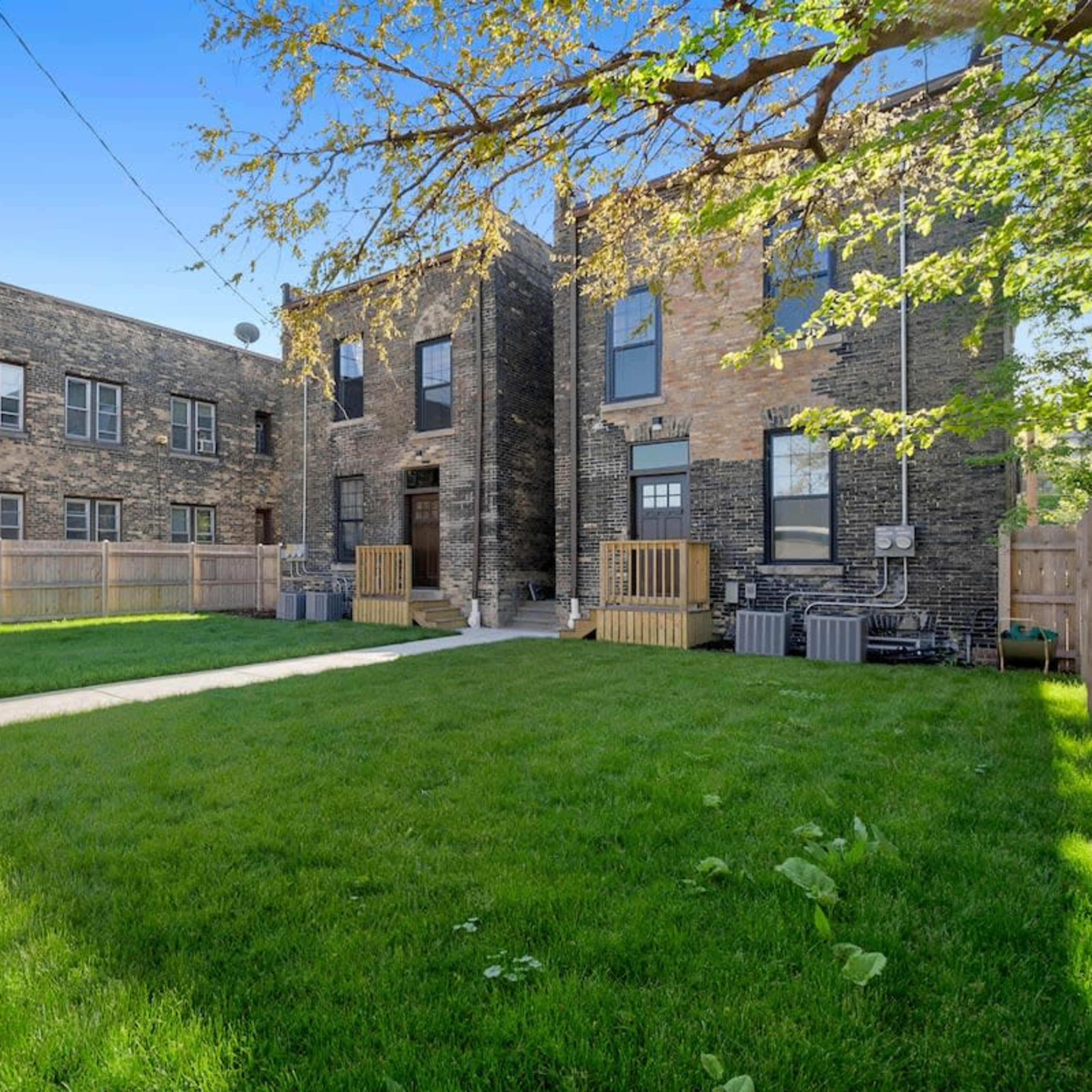 A two-story brick building complex with a grassy courtyard and a "Vacancy" sign.
