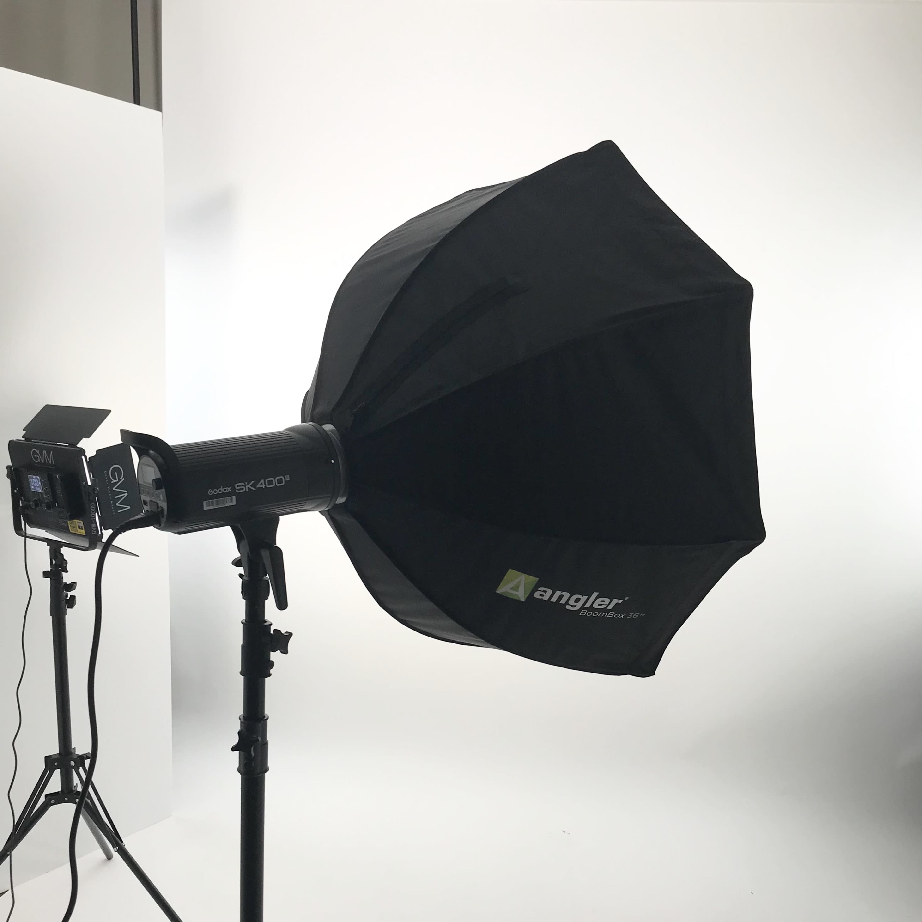 A softbox light mounted on a stand, positioned in a studio setting with a plain white background.