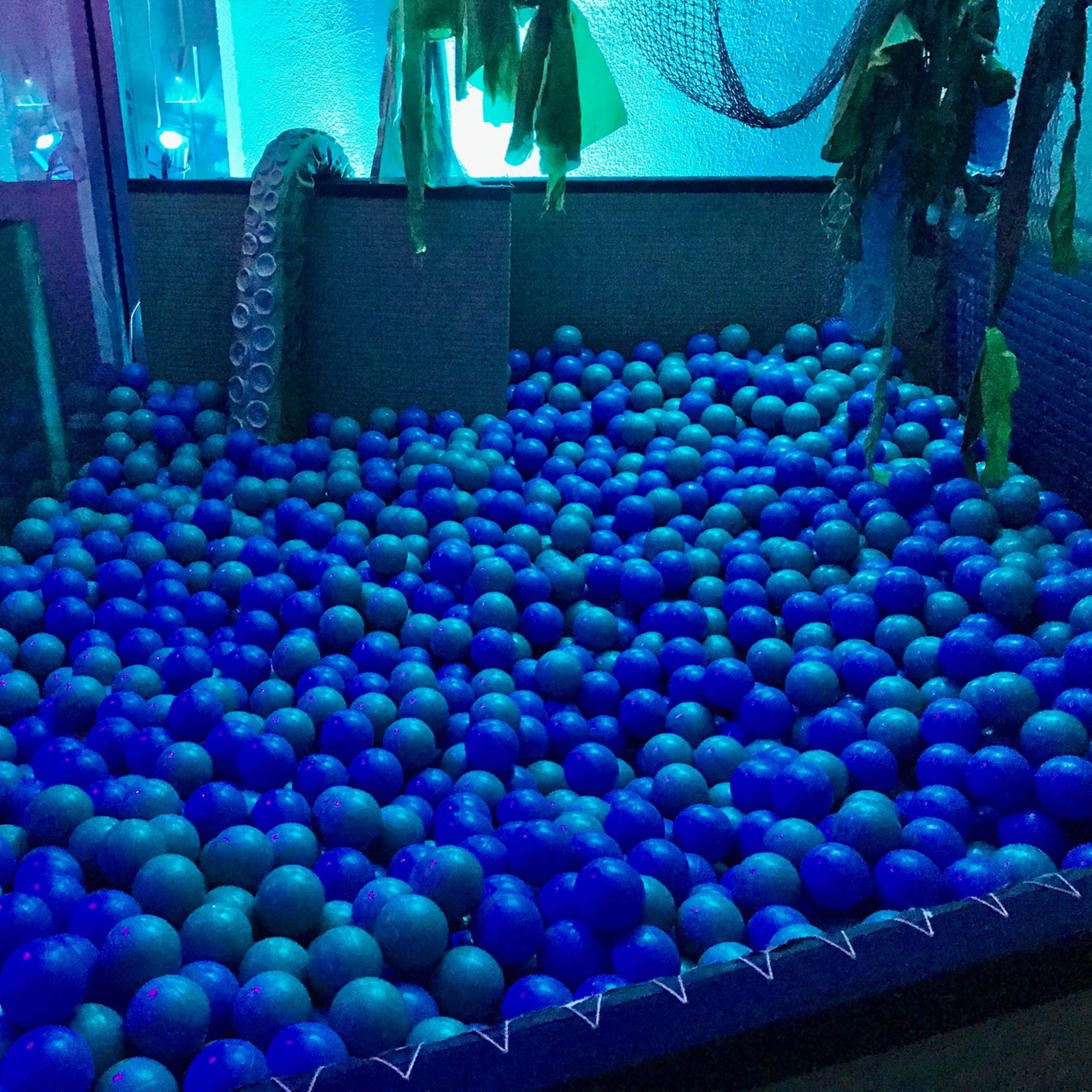 The scene features a pool filled with blue and green balls under vibrant lighting, surrounded by aquatic-themed decorations like an octopus and seaweed.