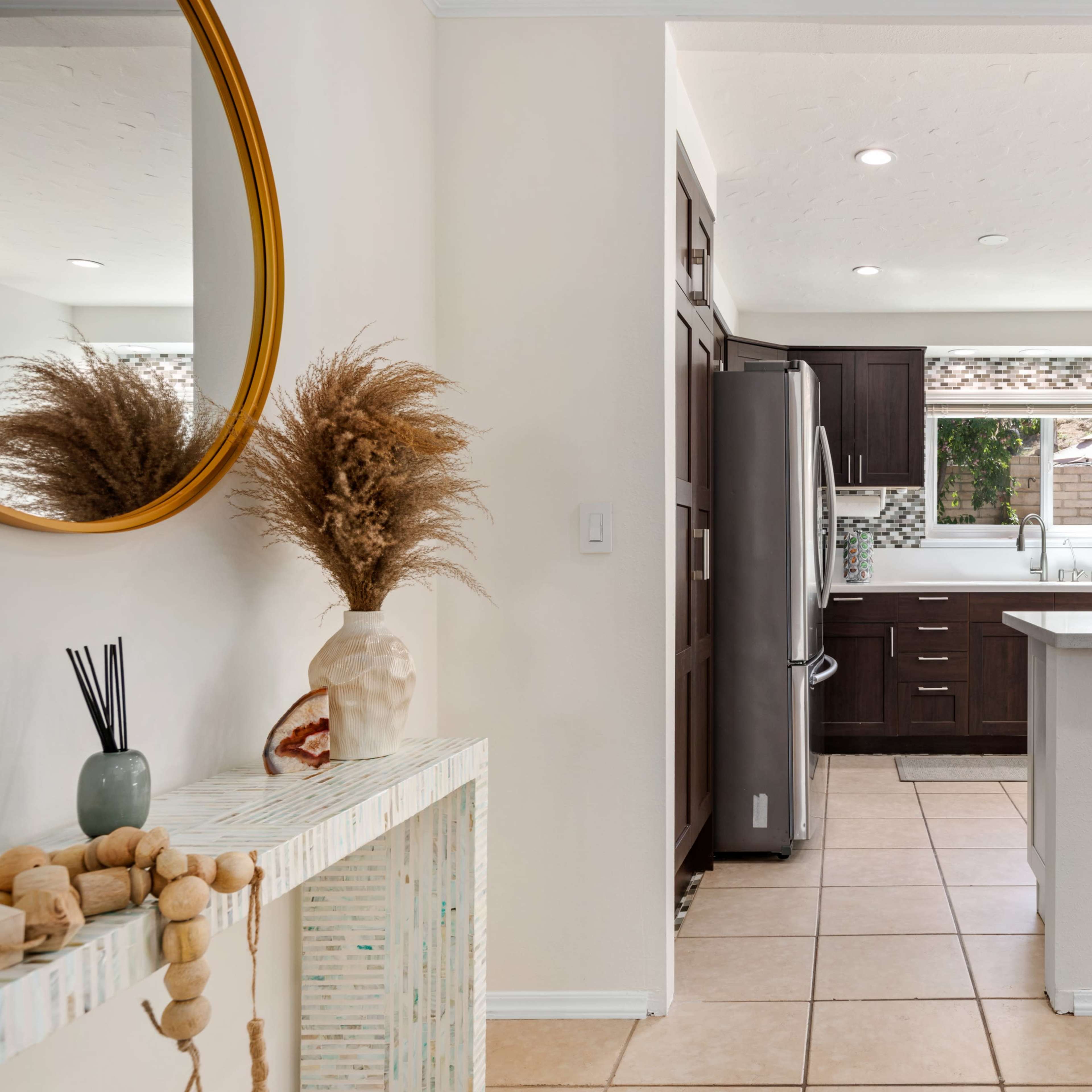 A modern kitchen and dining area with a sleek counter, appliances, and decorative elements.