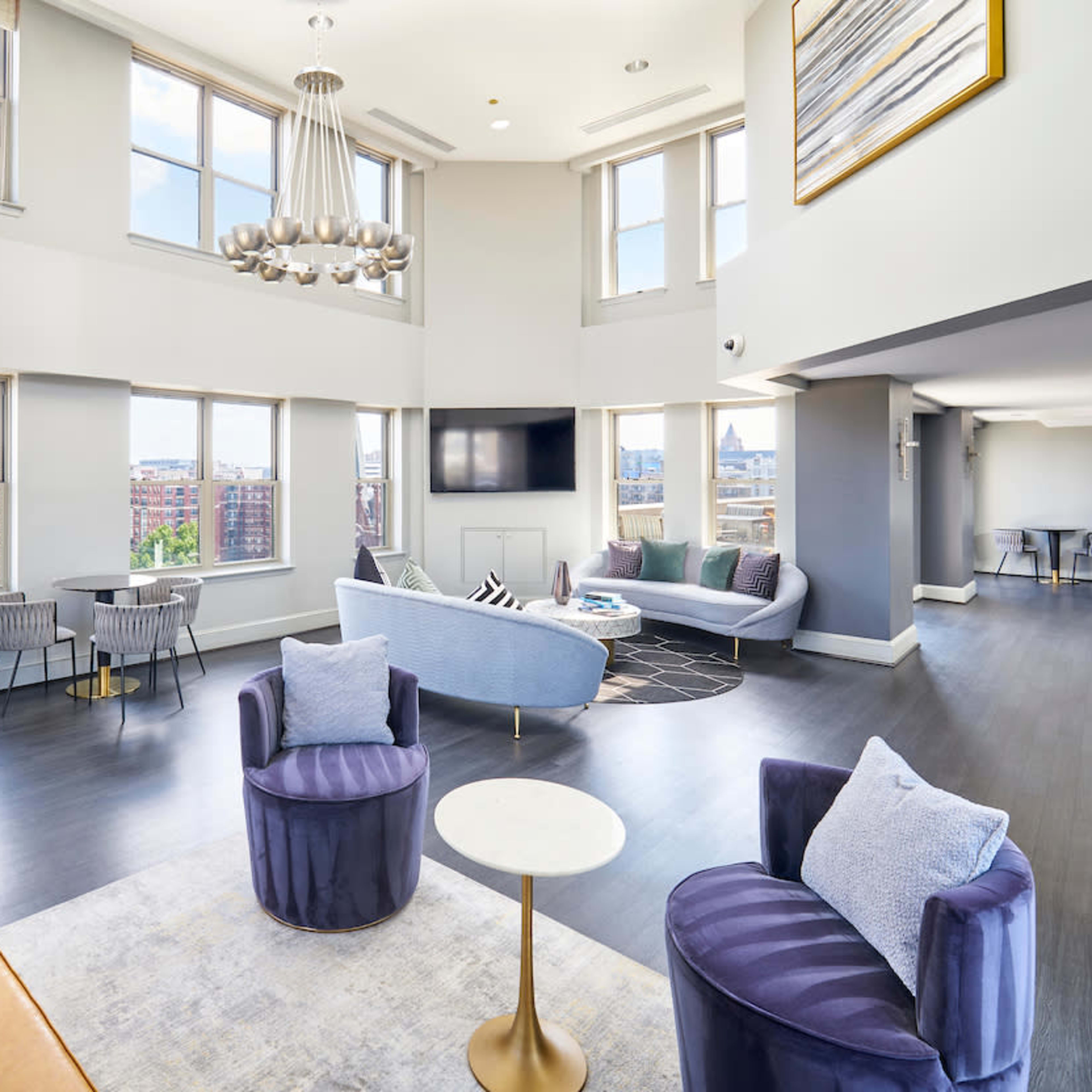 A spacious, modern living area with large windows, a fireplace, and contemporary furniture arranged for comfort.