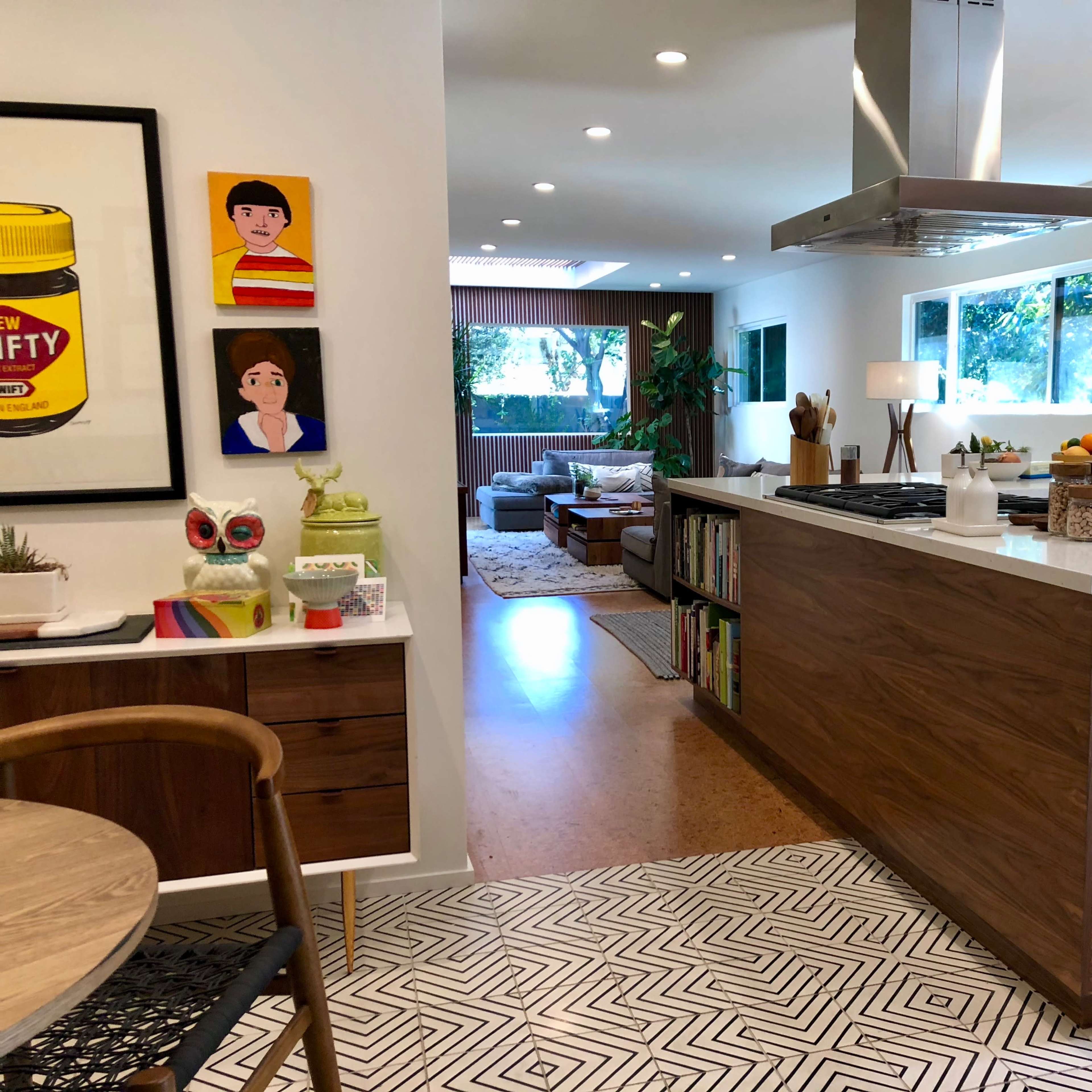 A modern kitchen with an island, hardwood cabinets, and an open layout connecting to a living area.