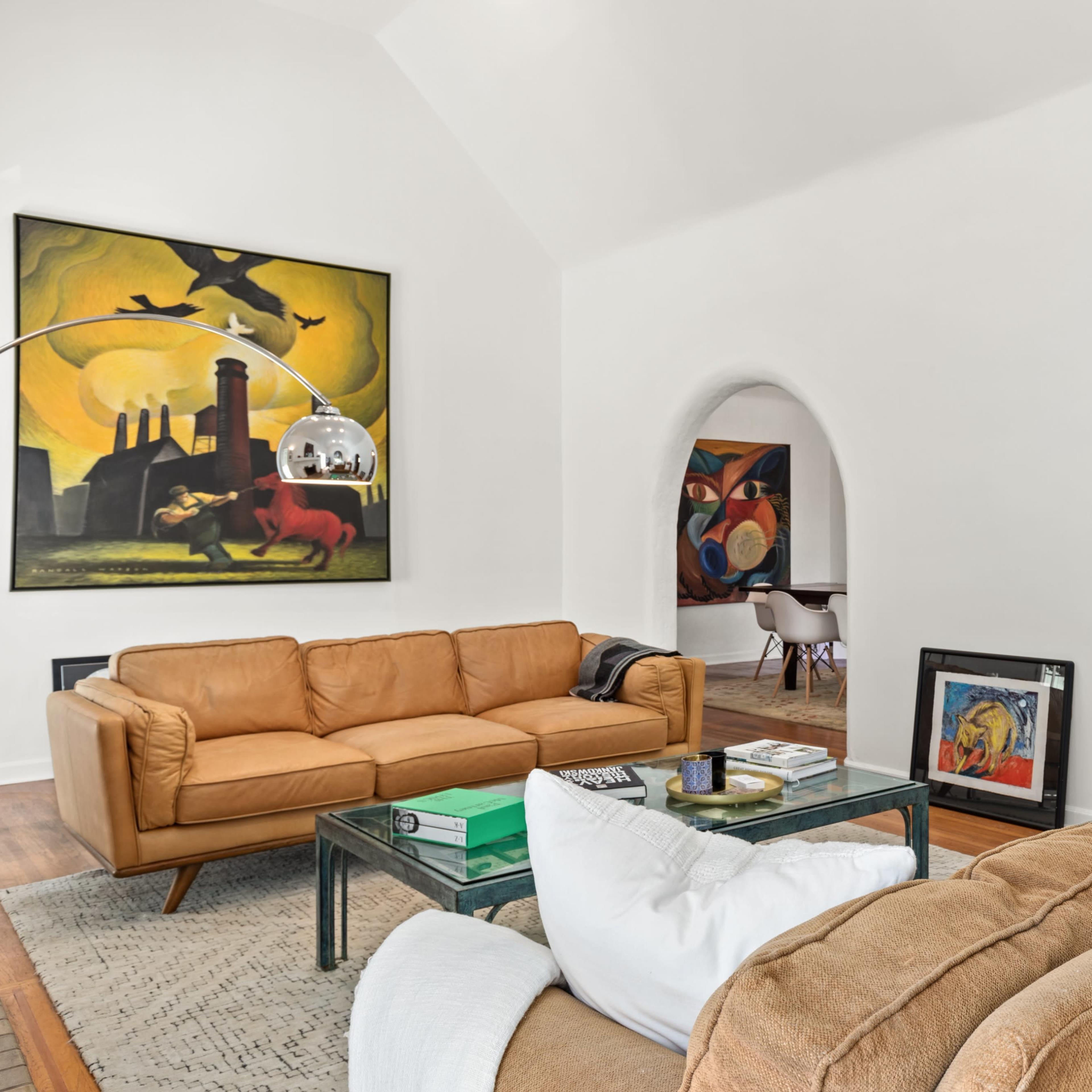 A living room with two sofas, art on the walls, and a vaulted ceiling.