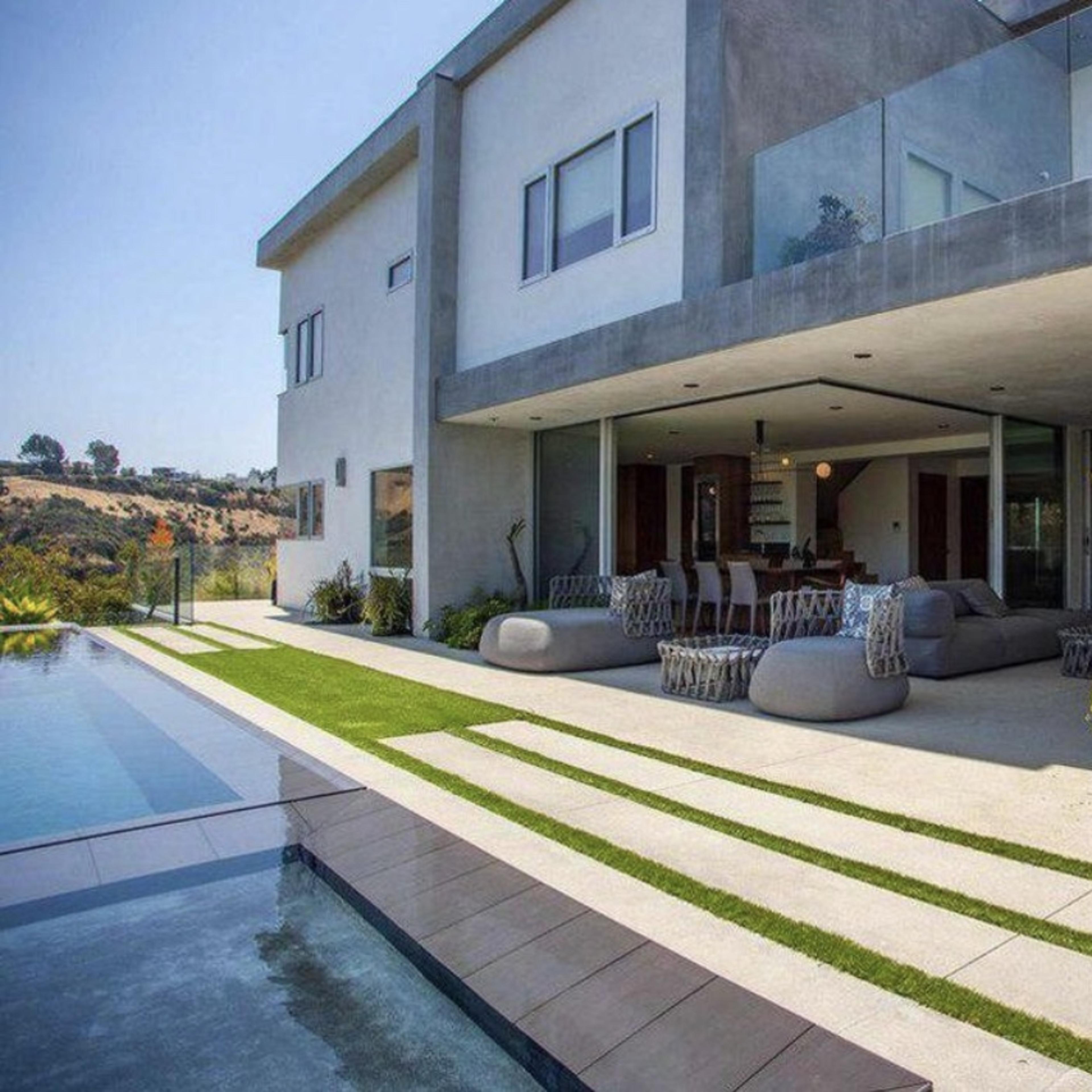 A modern two-story house with a spacious outdoor patio and a swimming pool.