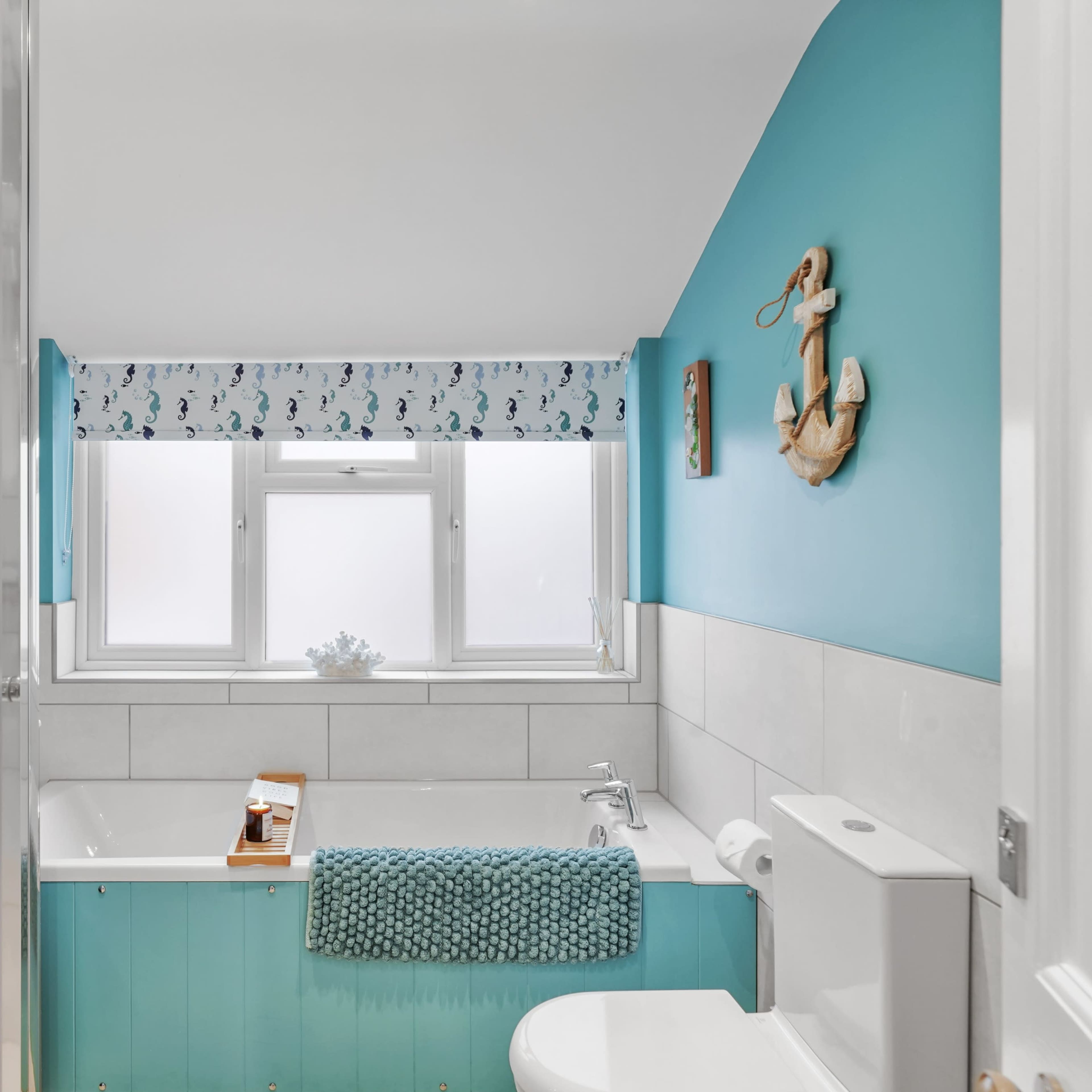The bathroom features a bathtub, white fixtures, and blue accent walls with nautical decor.