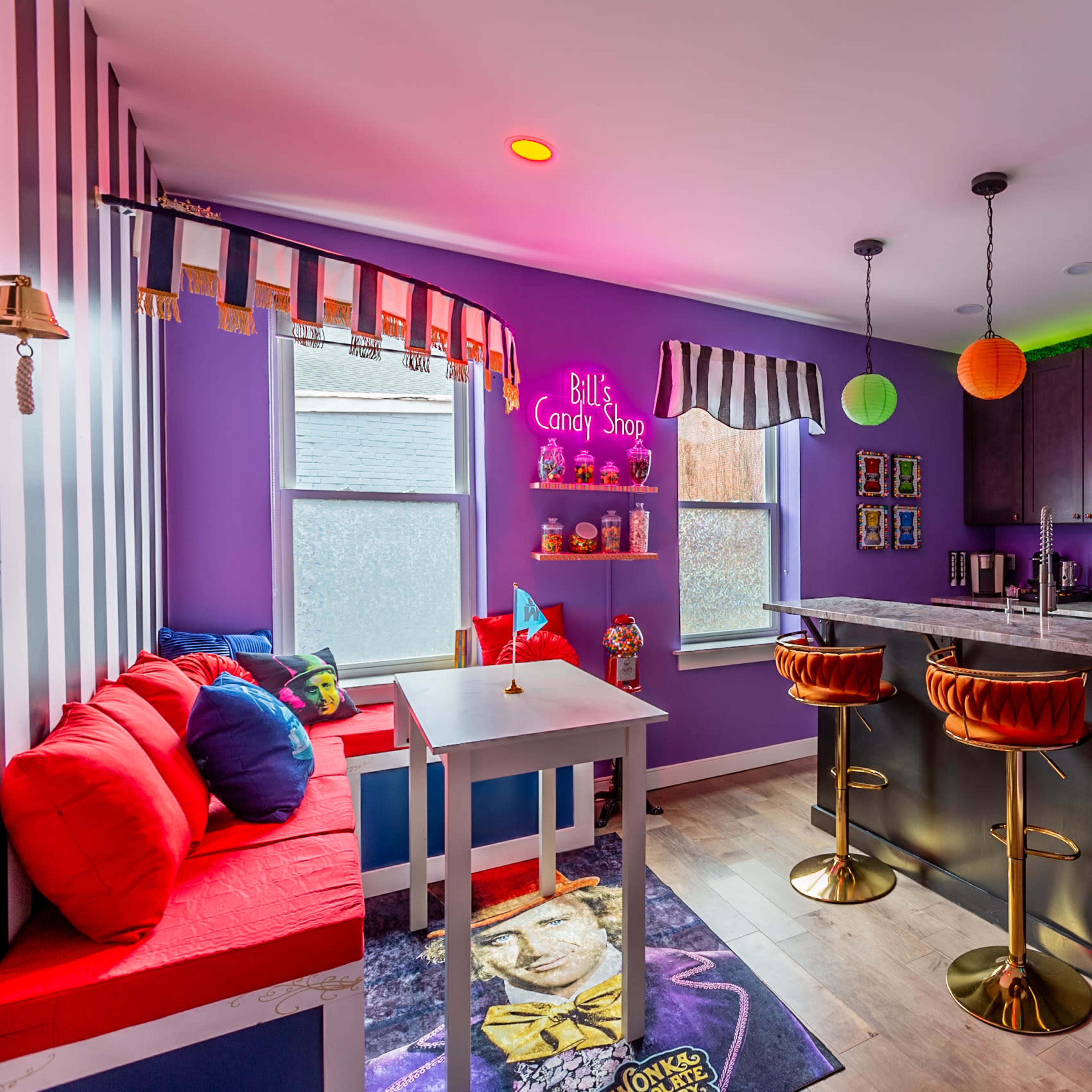 A colorful candy shop interior with bright decorations, seating, and a kitchen area featuring modern appliances.