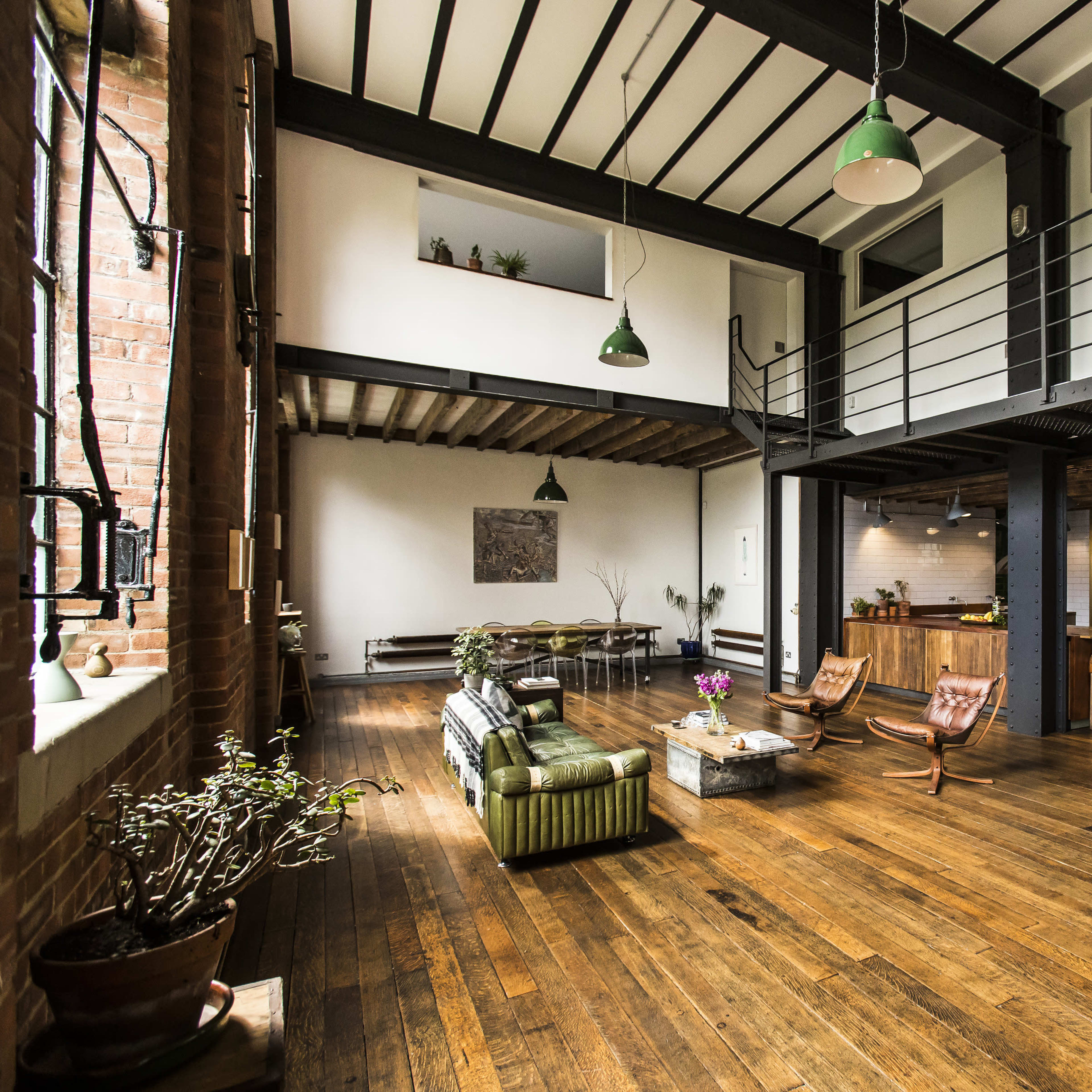 A spacious industrial-style loft with wooden floors, high ceilings, and a mix of modern and vintage furnishings.