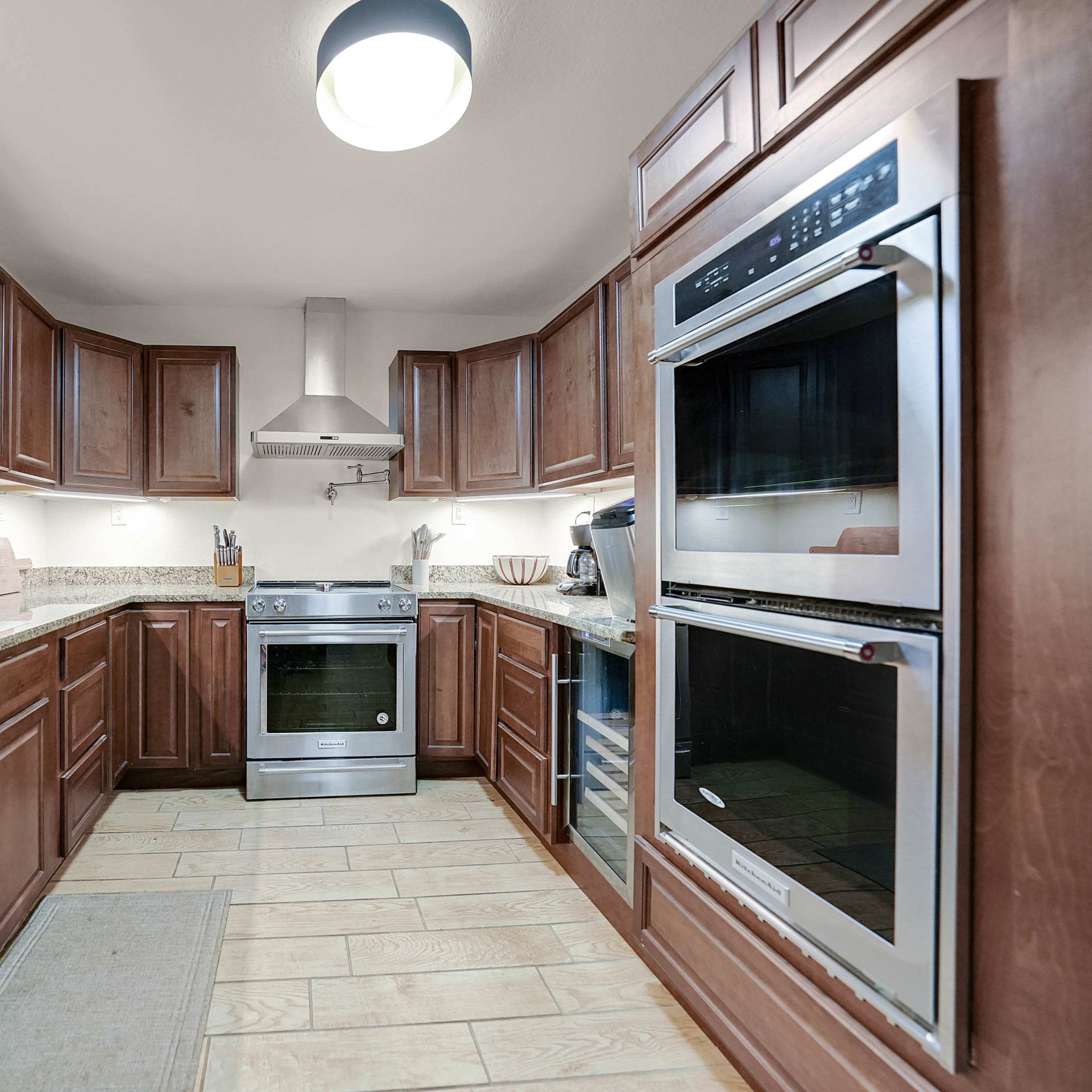 A modern kitchen featuring wooden cabinets, stainless steel appliances, and granite countertops.