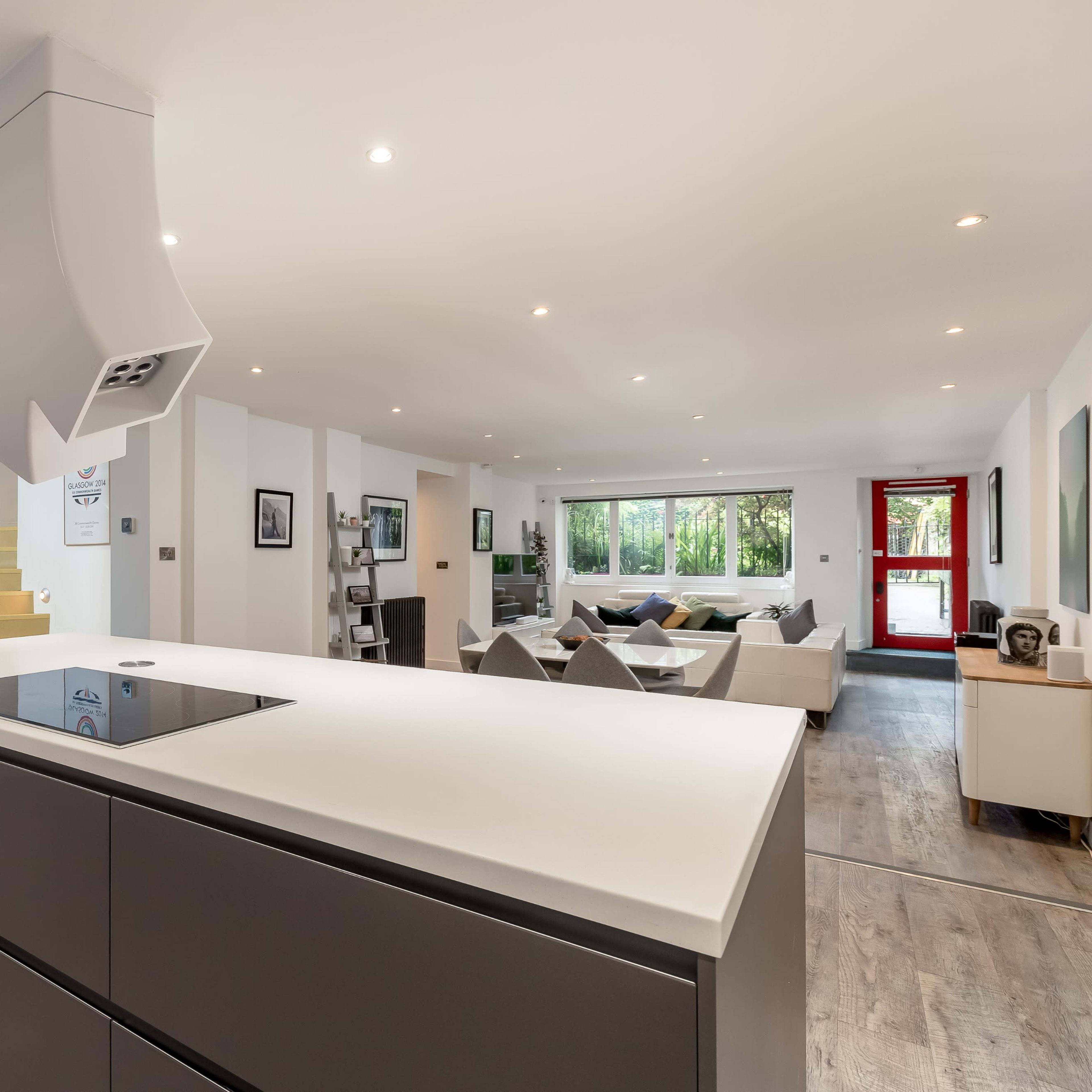 A modern open-concept kitchen and living area with a large kitchen island, sleek appliances, and a spacious seating area.