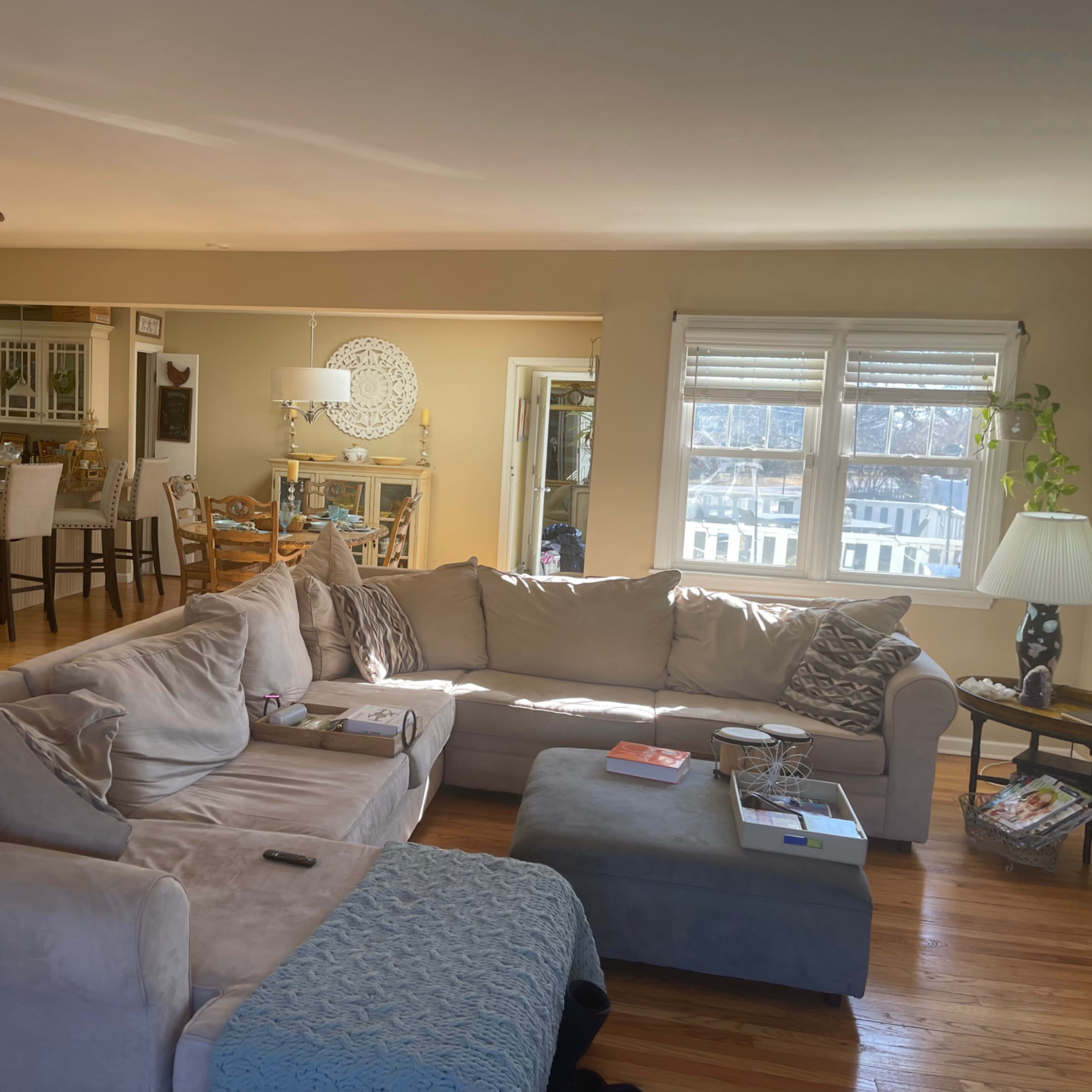 A spacious living room with a large sectional sofa, a coffee table, and a view into a kitchen area.