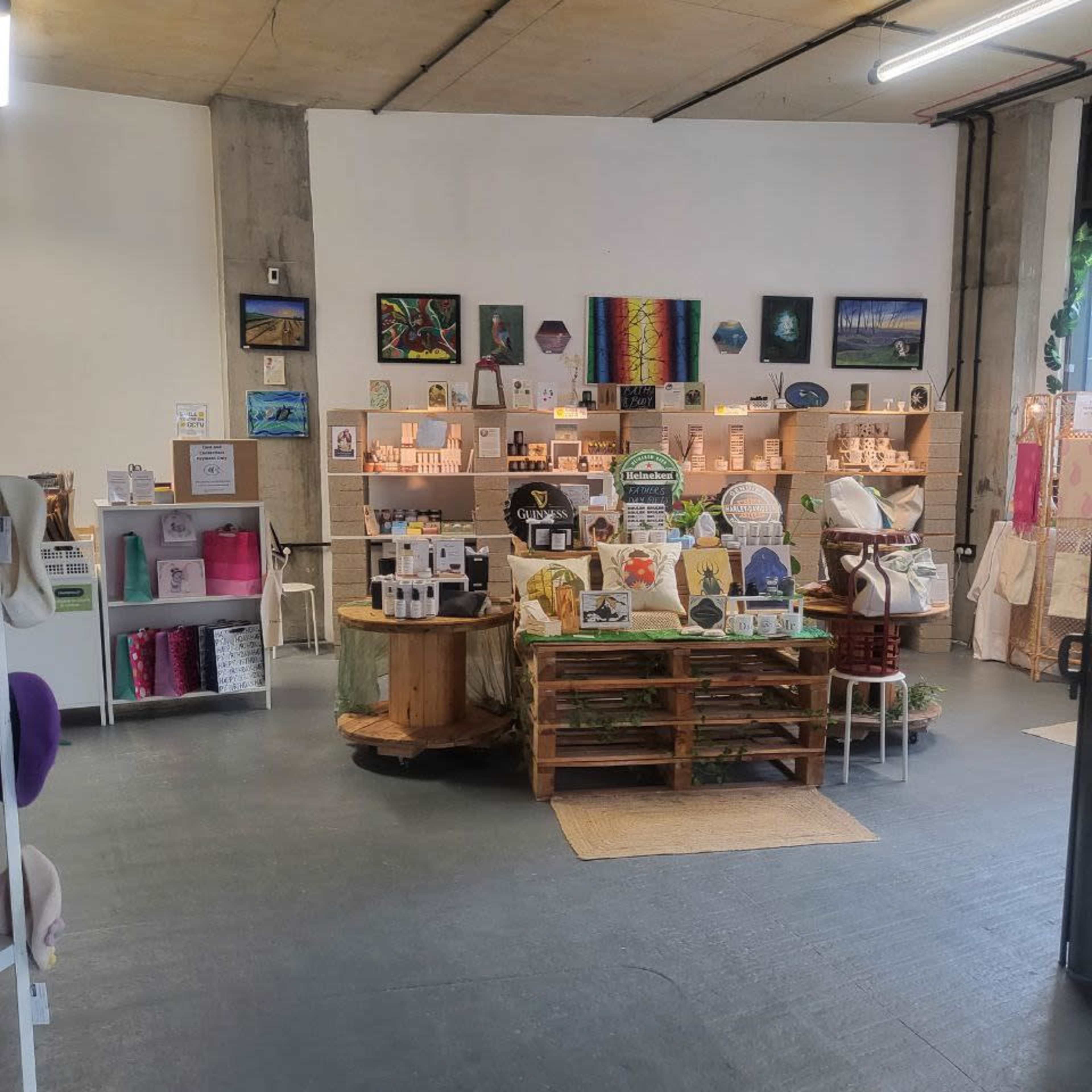 A colorful boutique displays various handmade items and artwork on shelves and tables.
