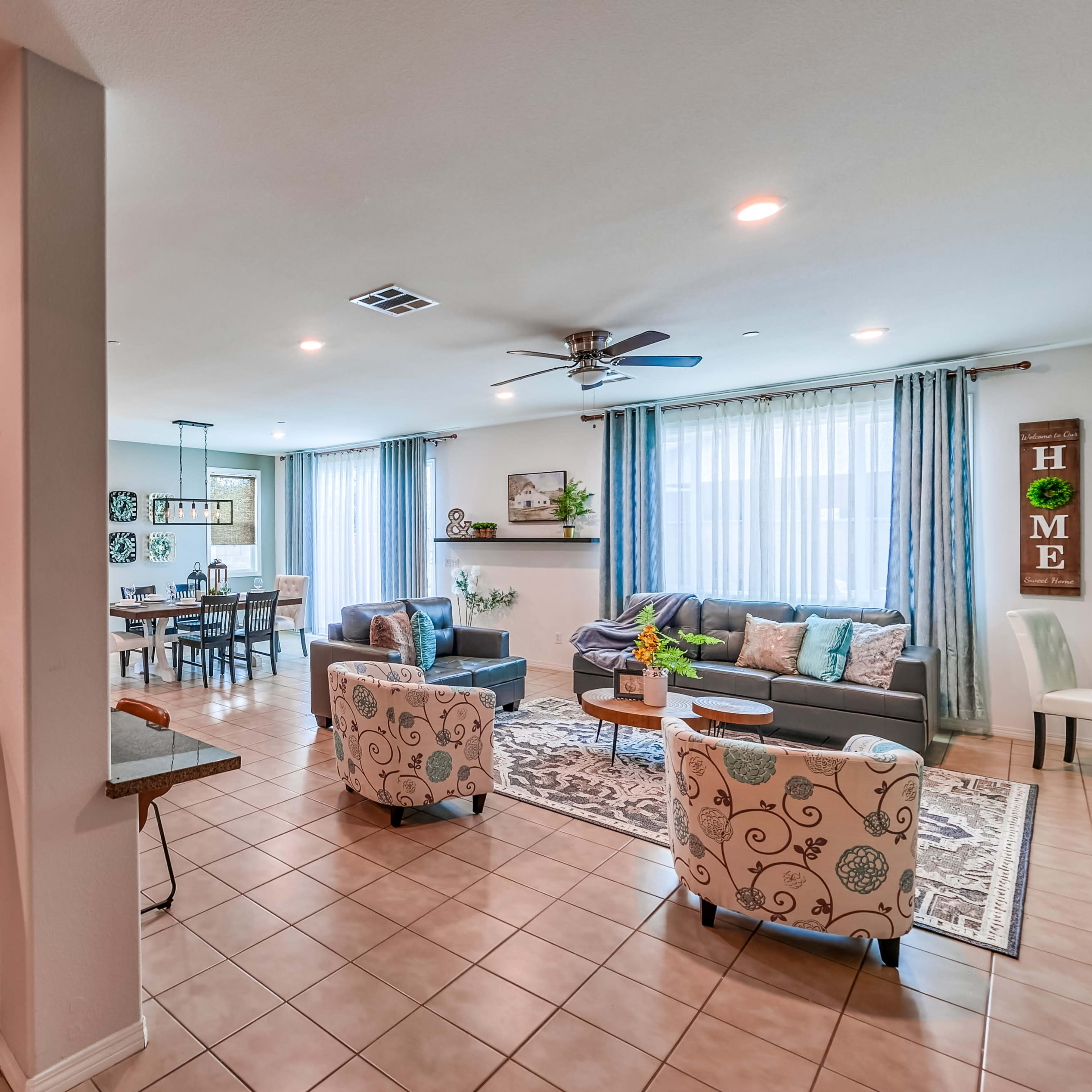 A spacious open-concept living area with a kitchen on one side and a cozy seating arrangement opposite a dining area.