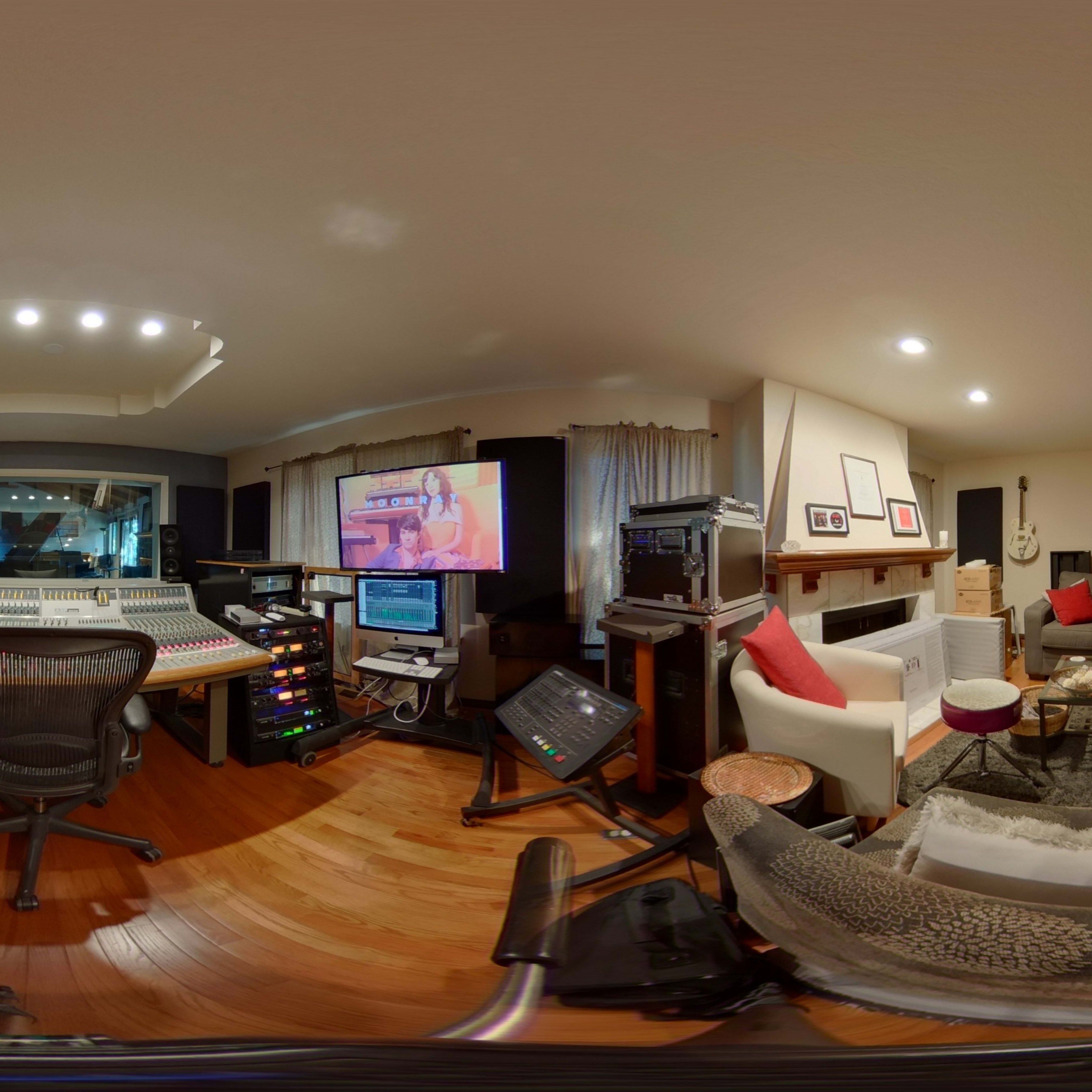A circular view of a music studio filled with recording equipment, instruments, and soundproofing materials.