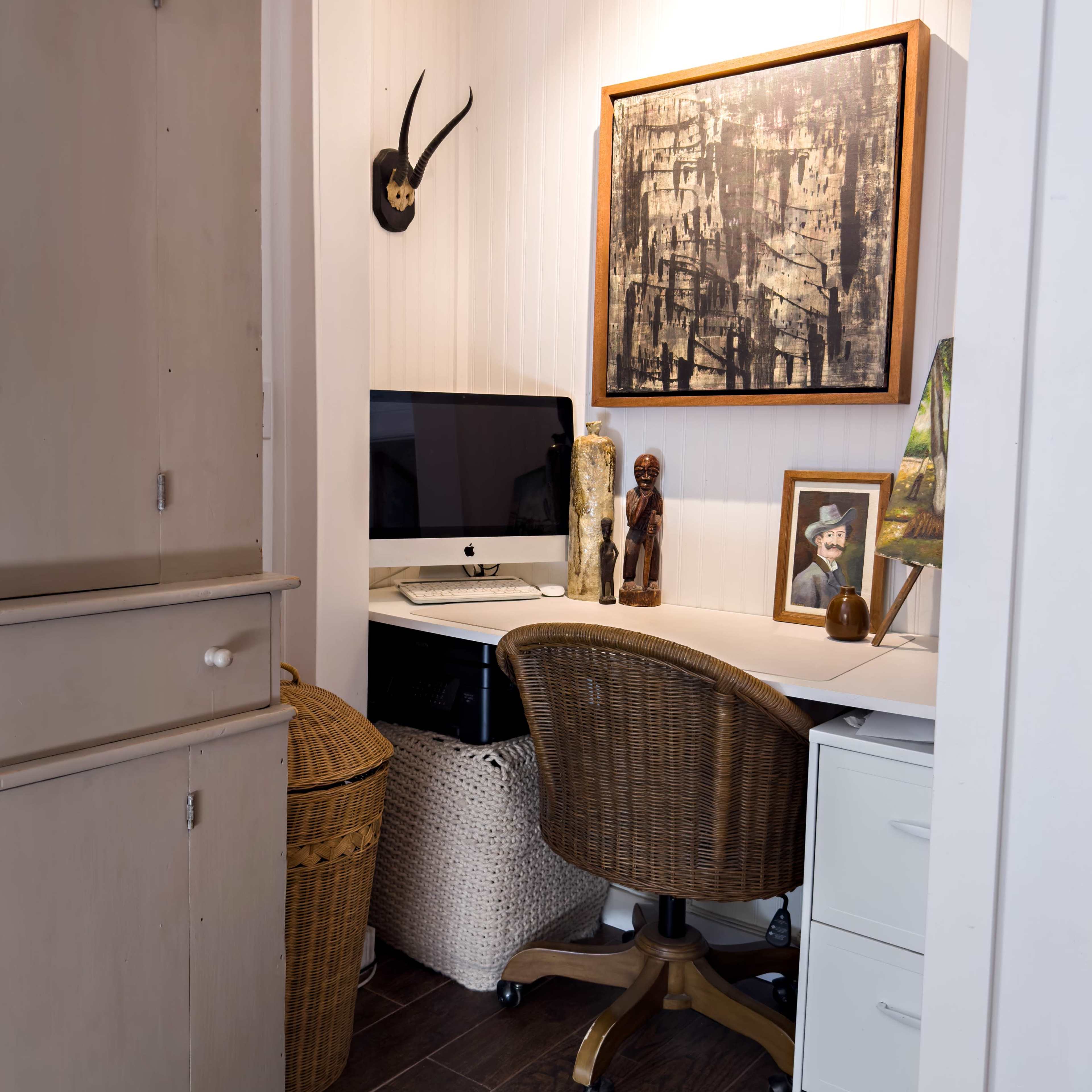 A small workspace with a computer and chair, flanked by decorative items and storage baskets.