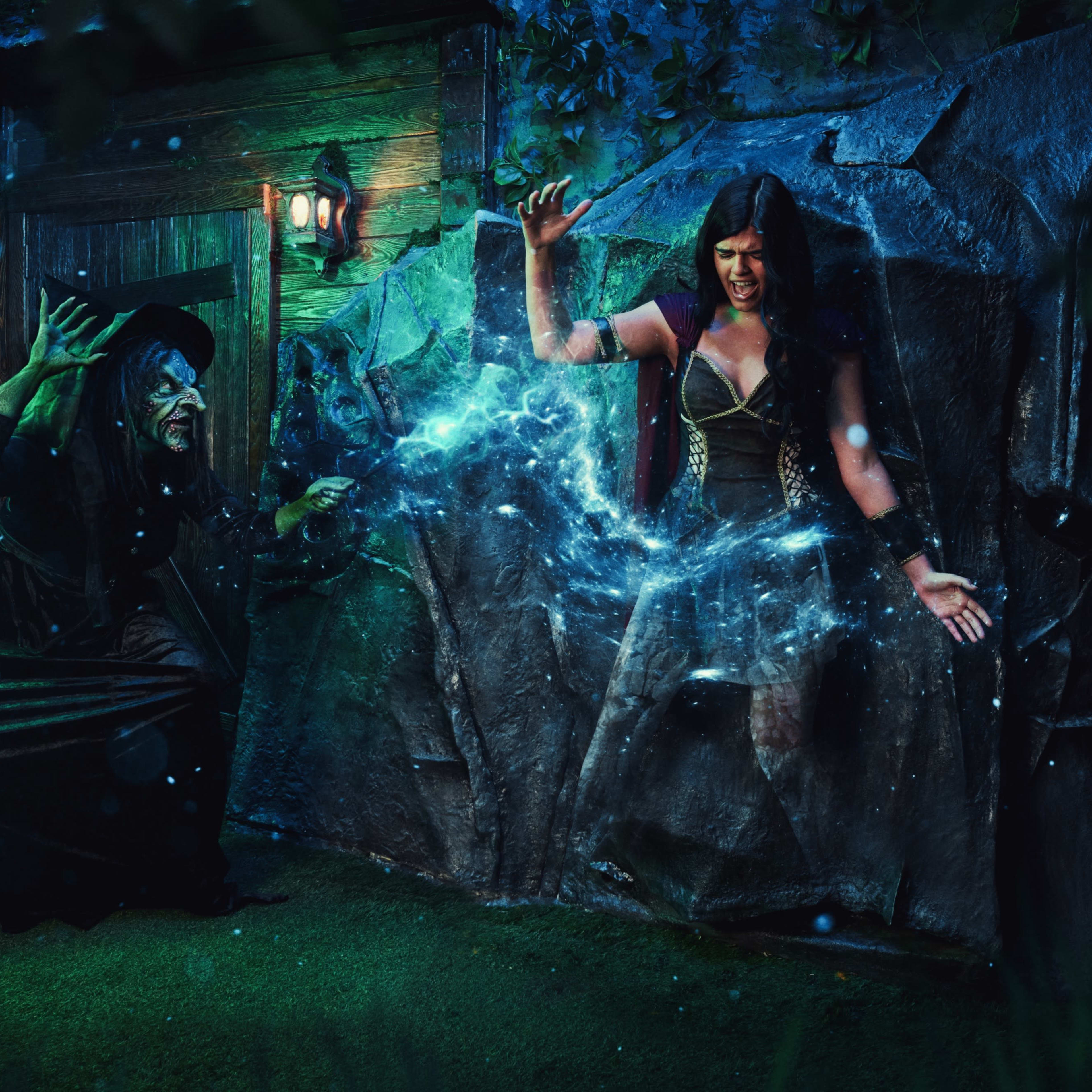 A cloaked figure casts a magical spell on a woman who appears to be trapped within a mystical barrier in a dimly lit, enchanted setting.