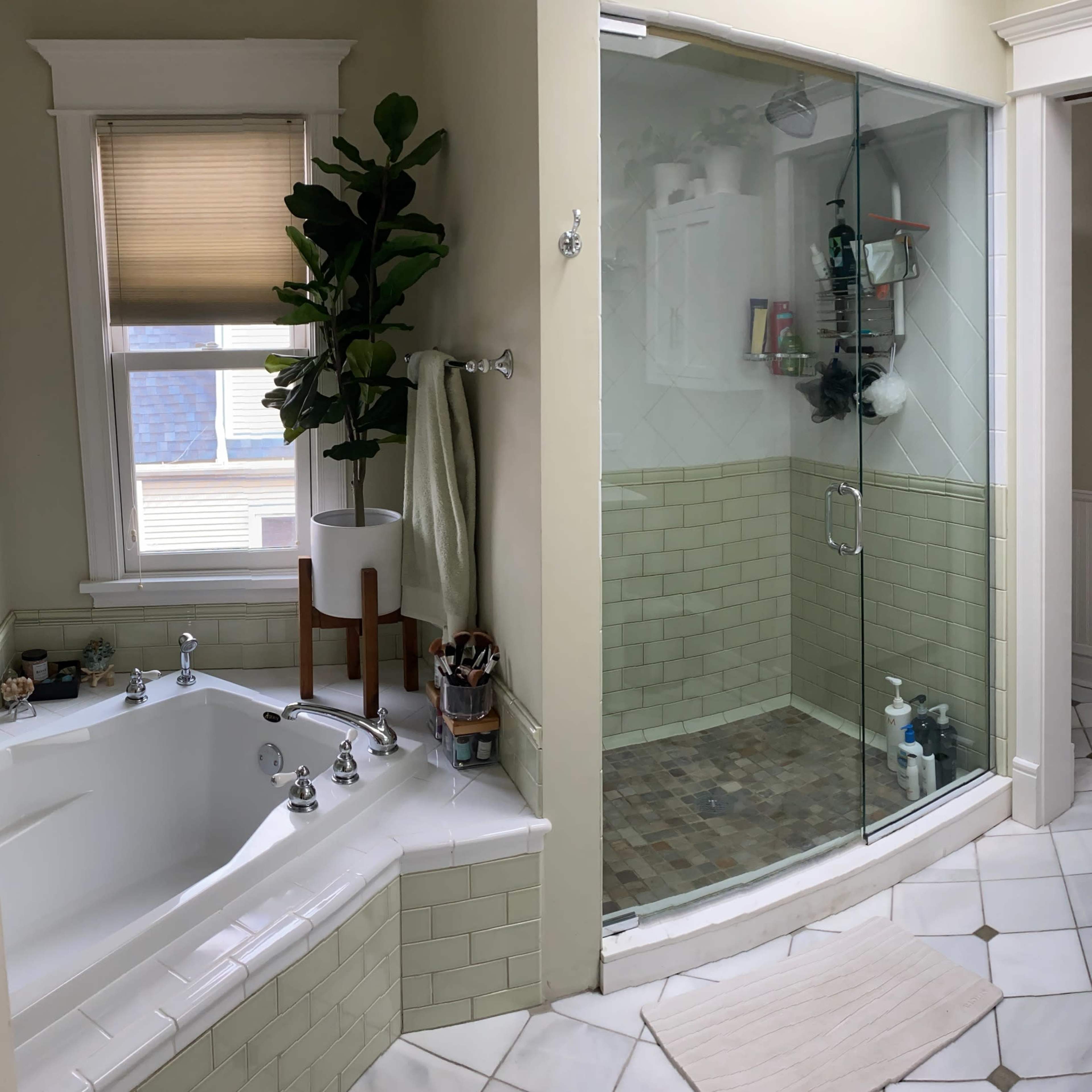 A bathroom featuring a glass shower, a freestanding bathtub, and a double vanity with a large mirror.