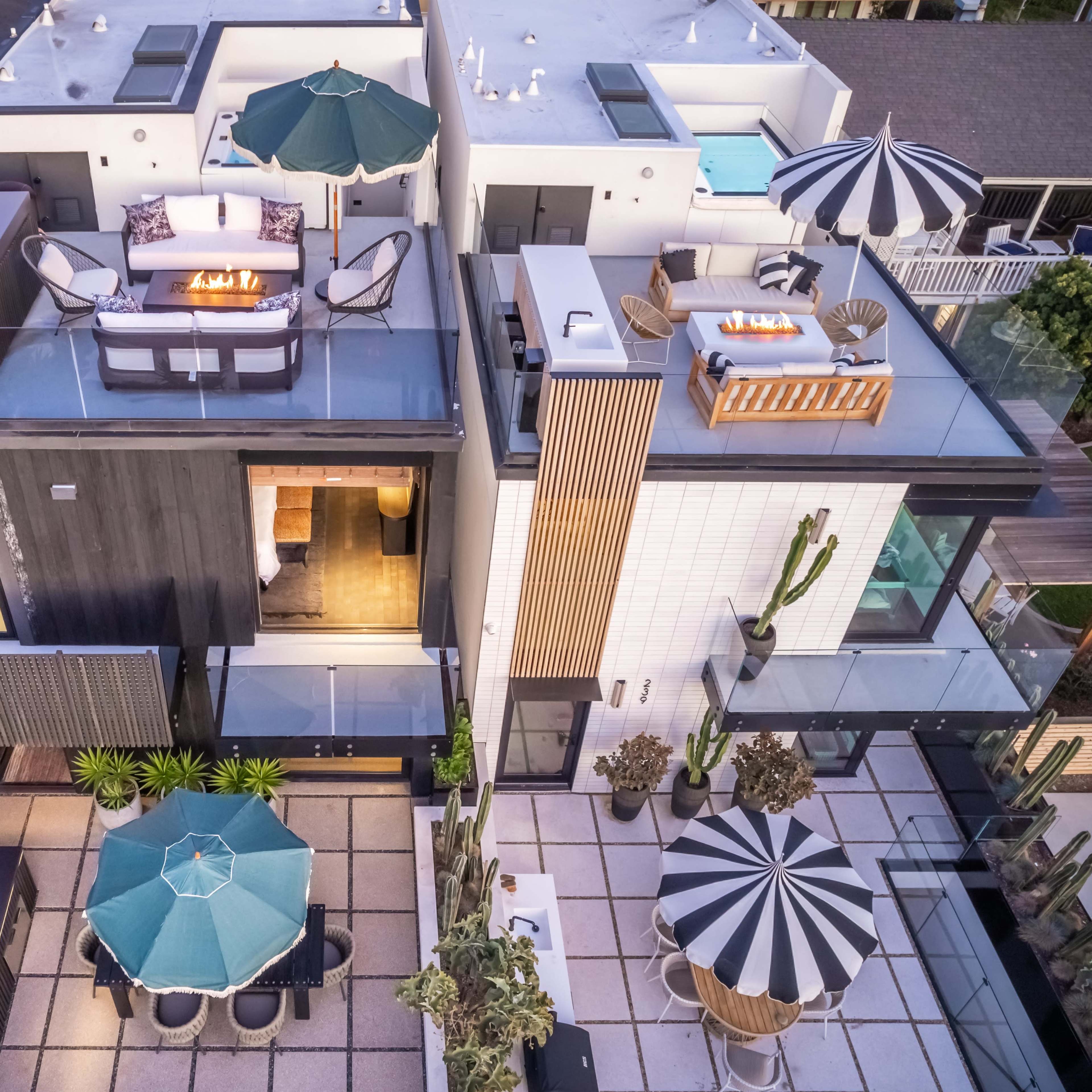 A modern multi-level residence with various outdoor seating areas, including a rooftop terrace and a patio surrounded by greenery.