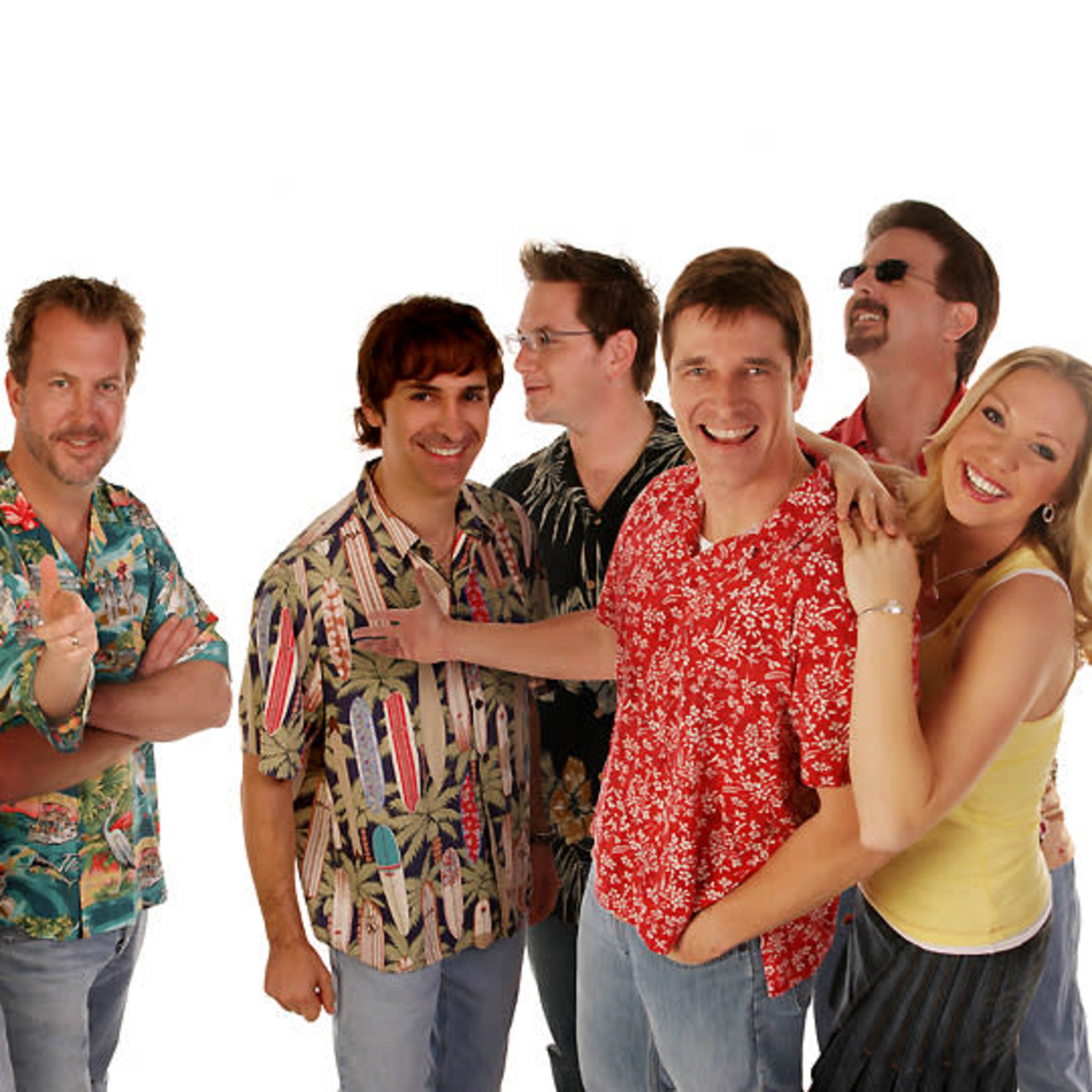 A group of six men and one woman stands together, wearing colorful tropical shirts against a white background.